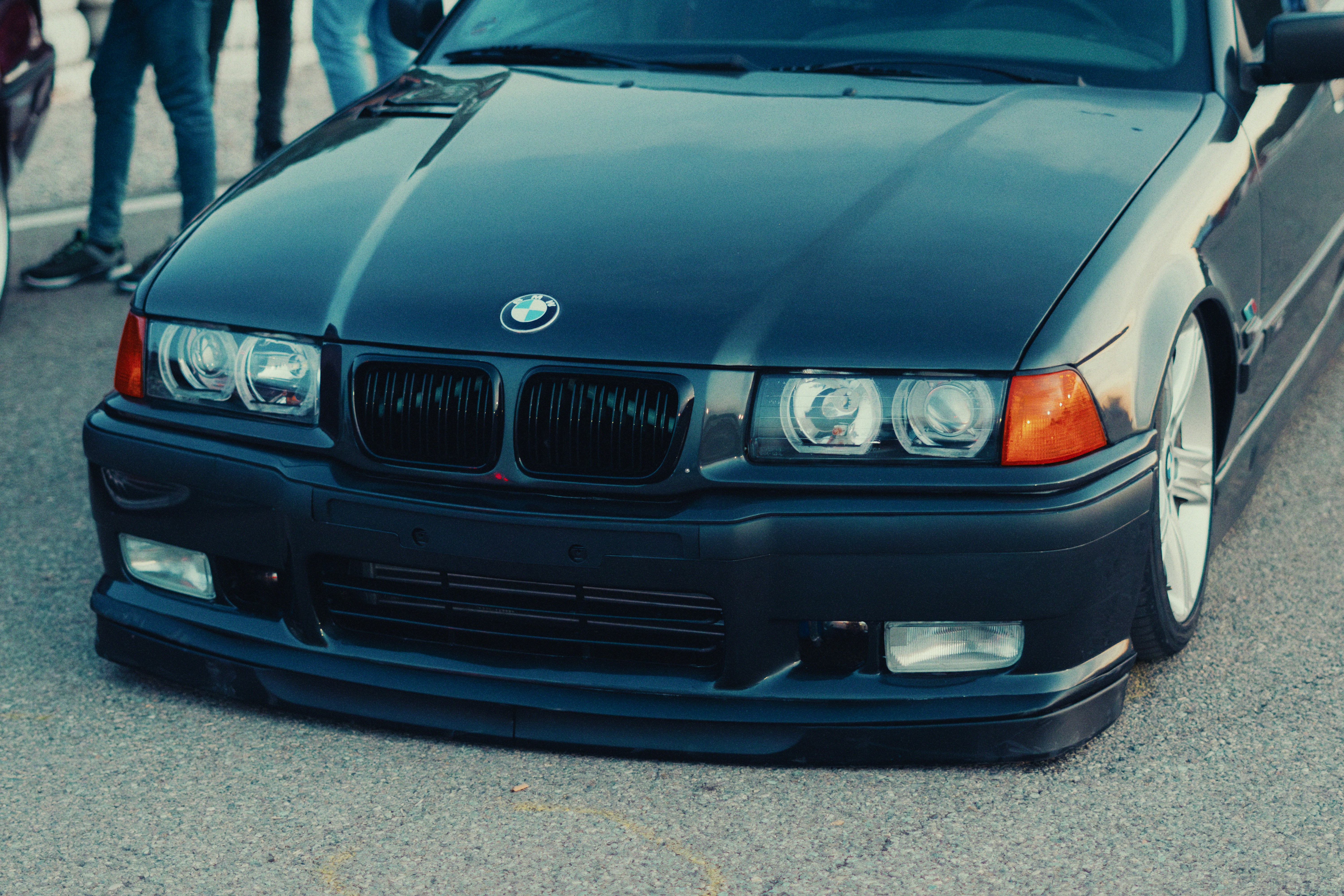 A dark BMW car's front with headlights and grille