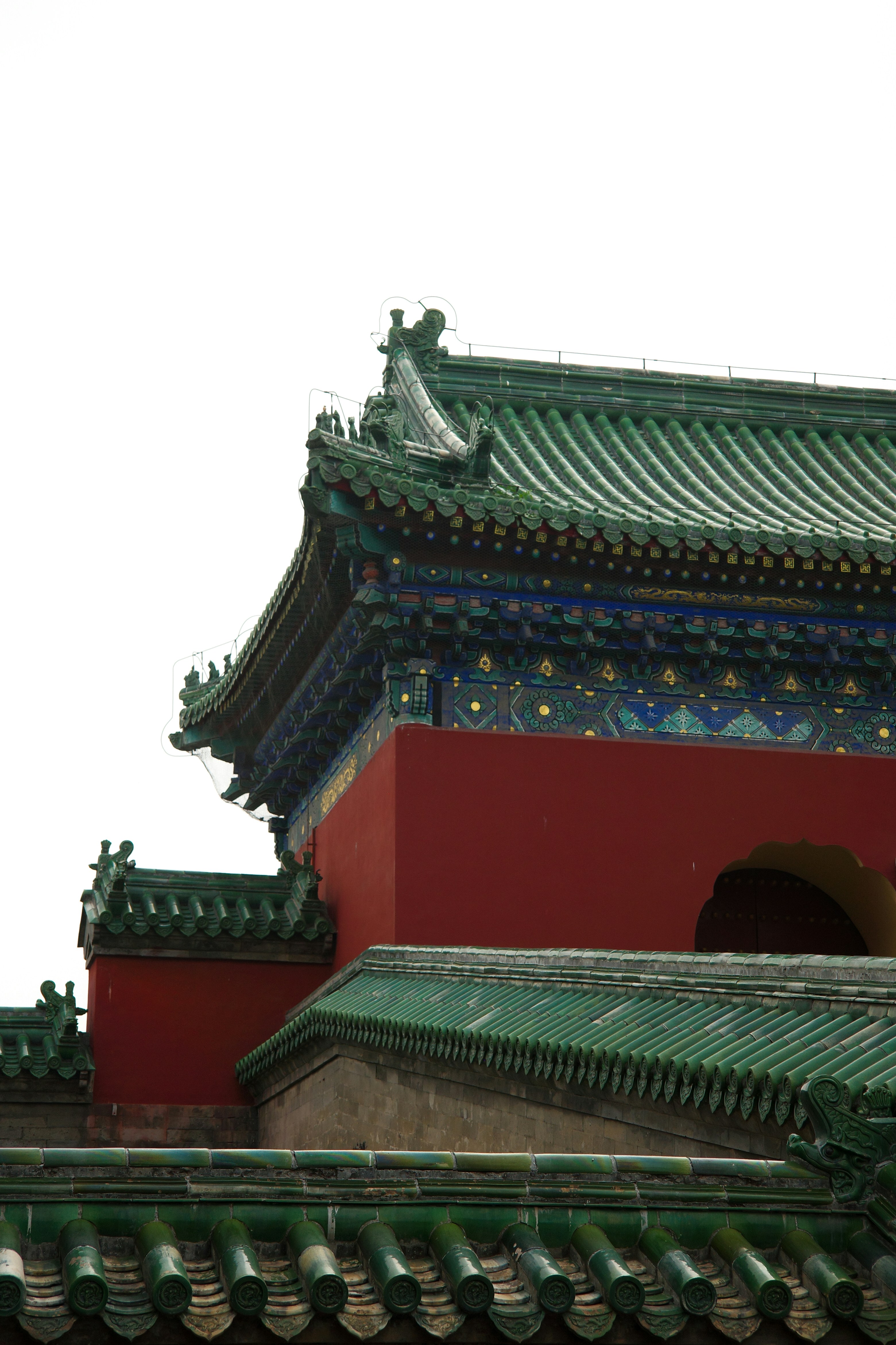 Ornate chinese temple architecture with green roofs and red walls.
