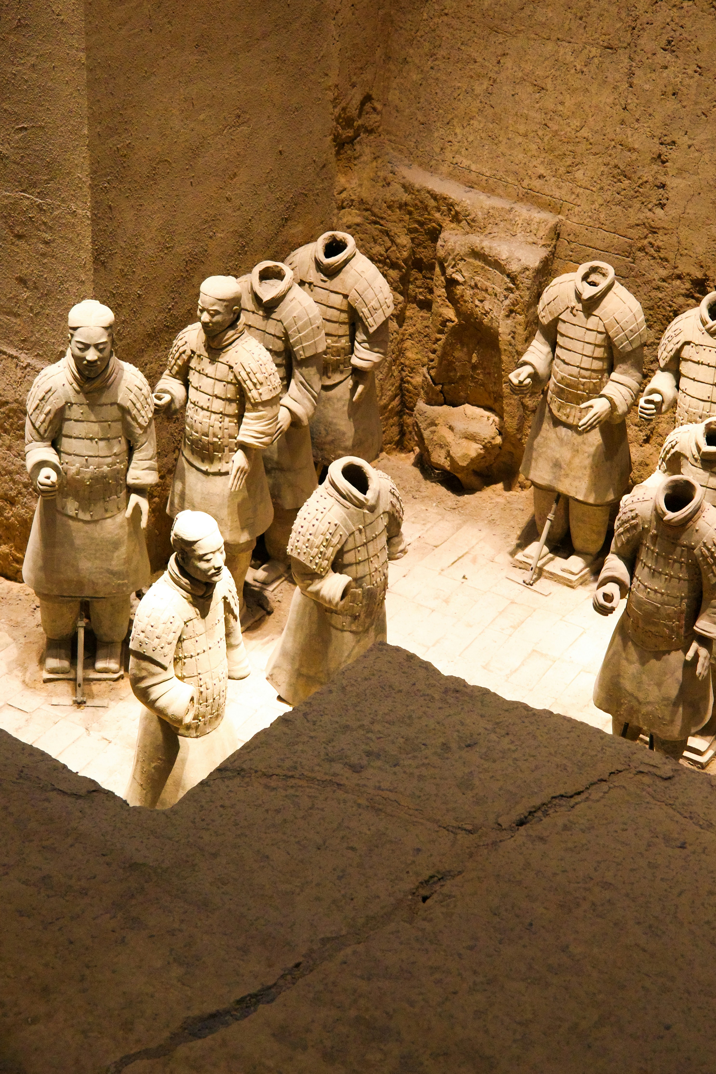 Terracotta warriors standing in an excavated pit.