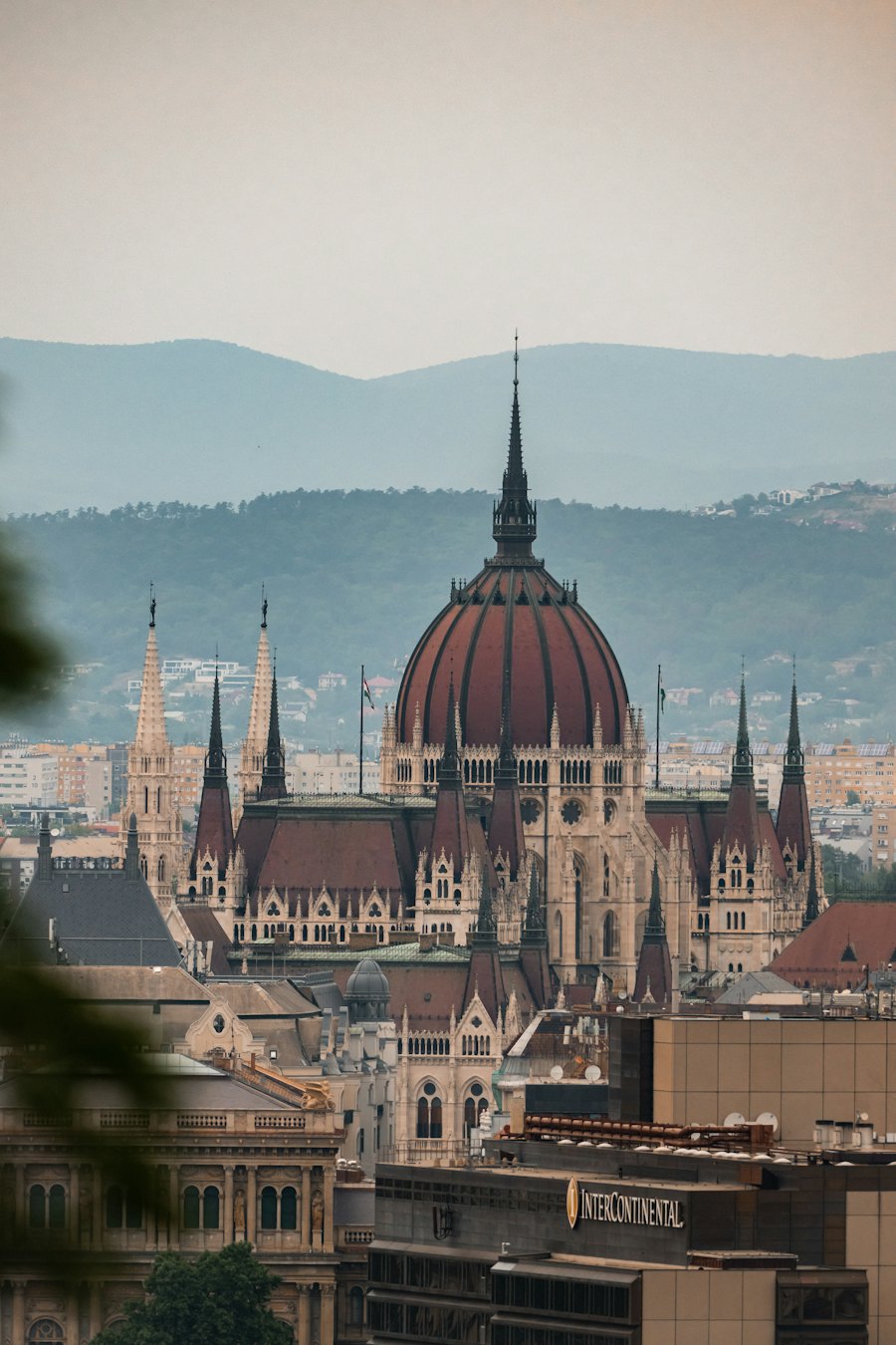 The dome and spires of the Hungarian Parliament against the hills of Buda