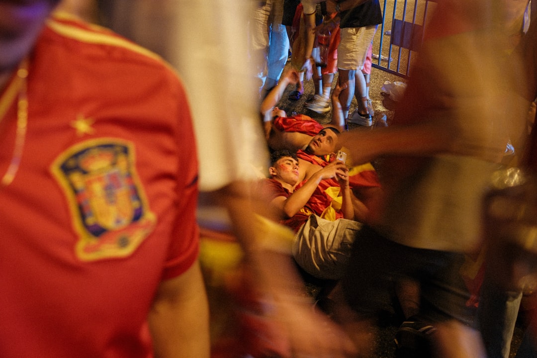 Spanish shirt in foreground, person on ground in crowd.