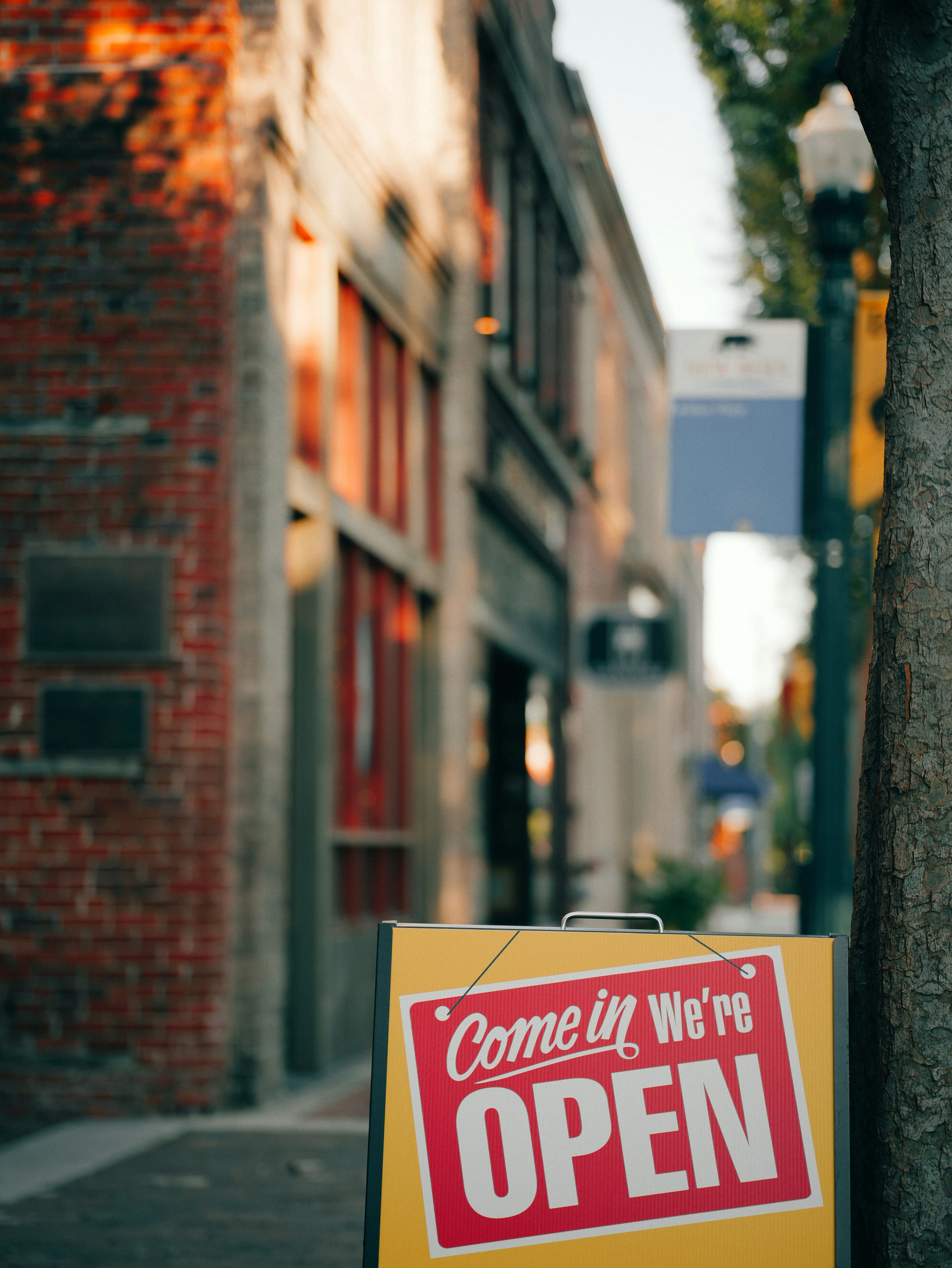 Come in we're open sign on blurred street