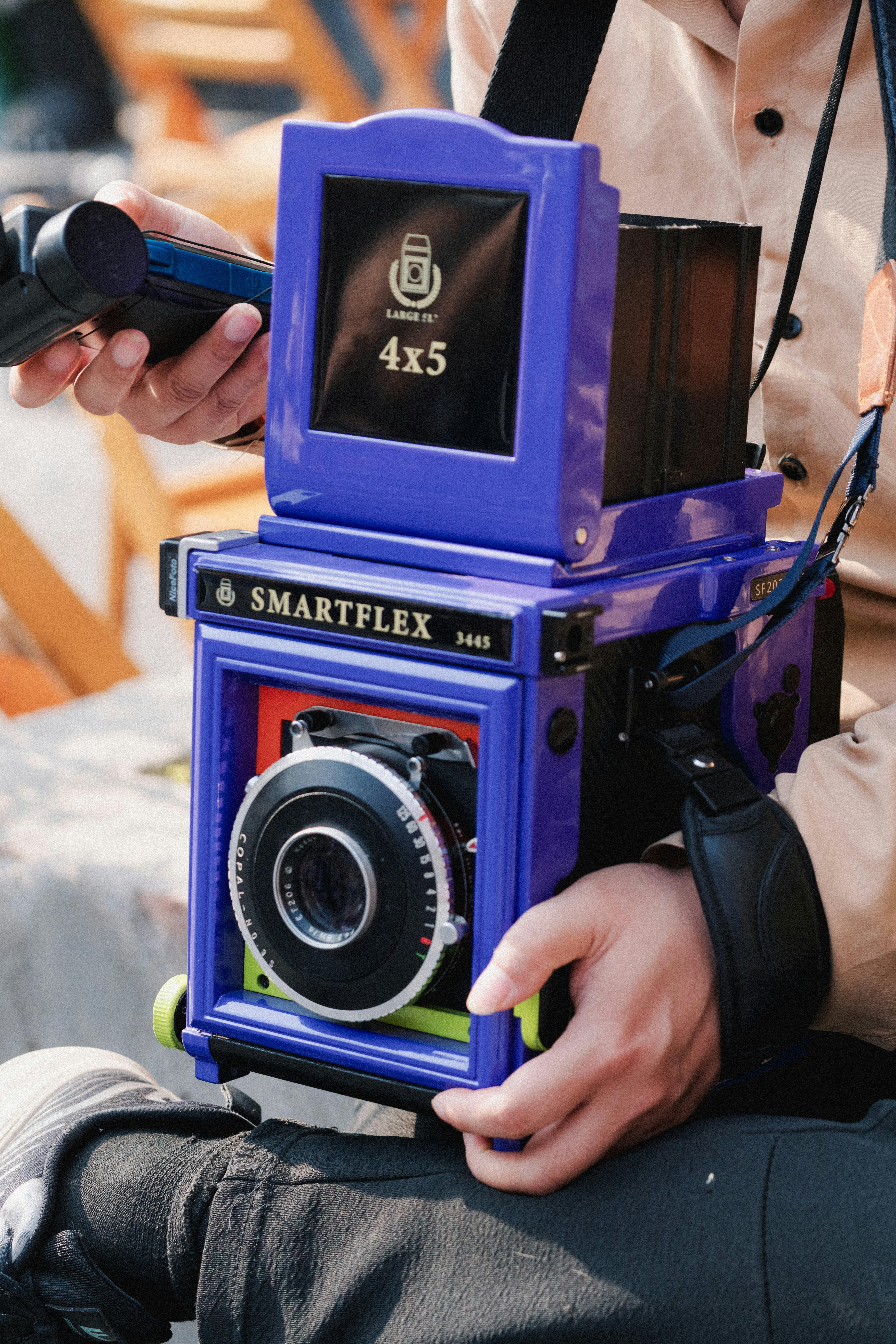 A person holds a purple smartflex 4x5 large format camera.
