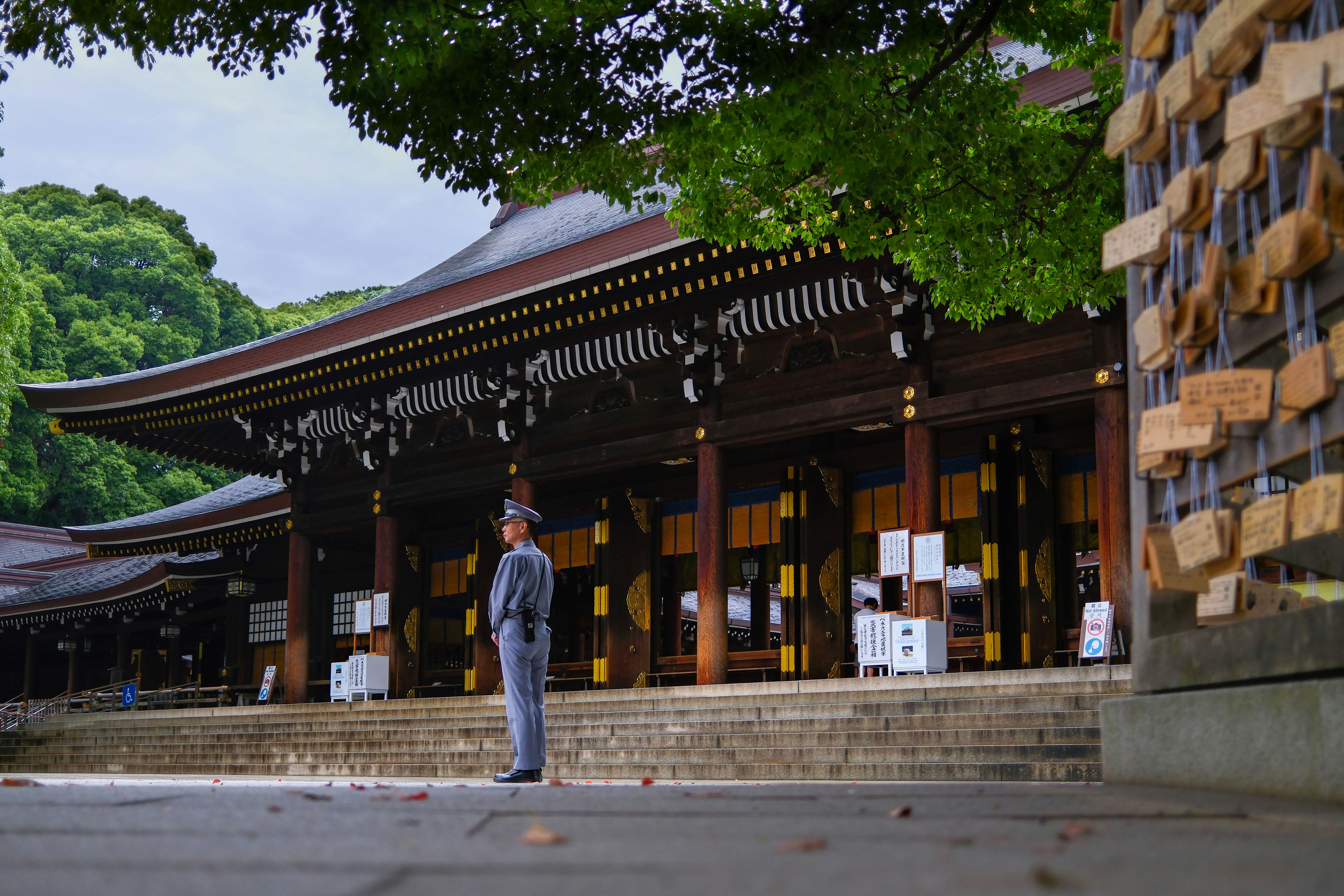 Man standing at a japanese temple with prayer plaques
