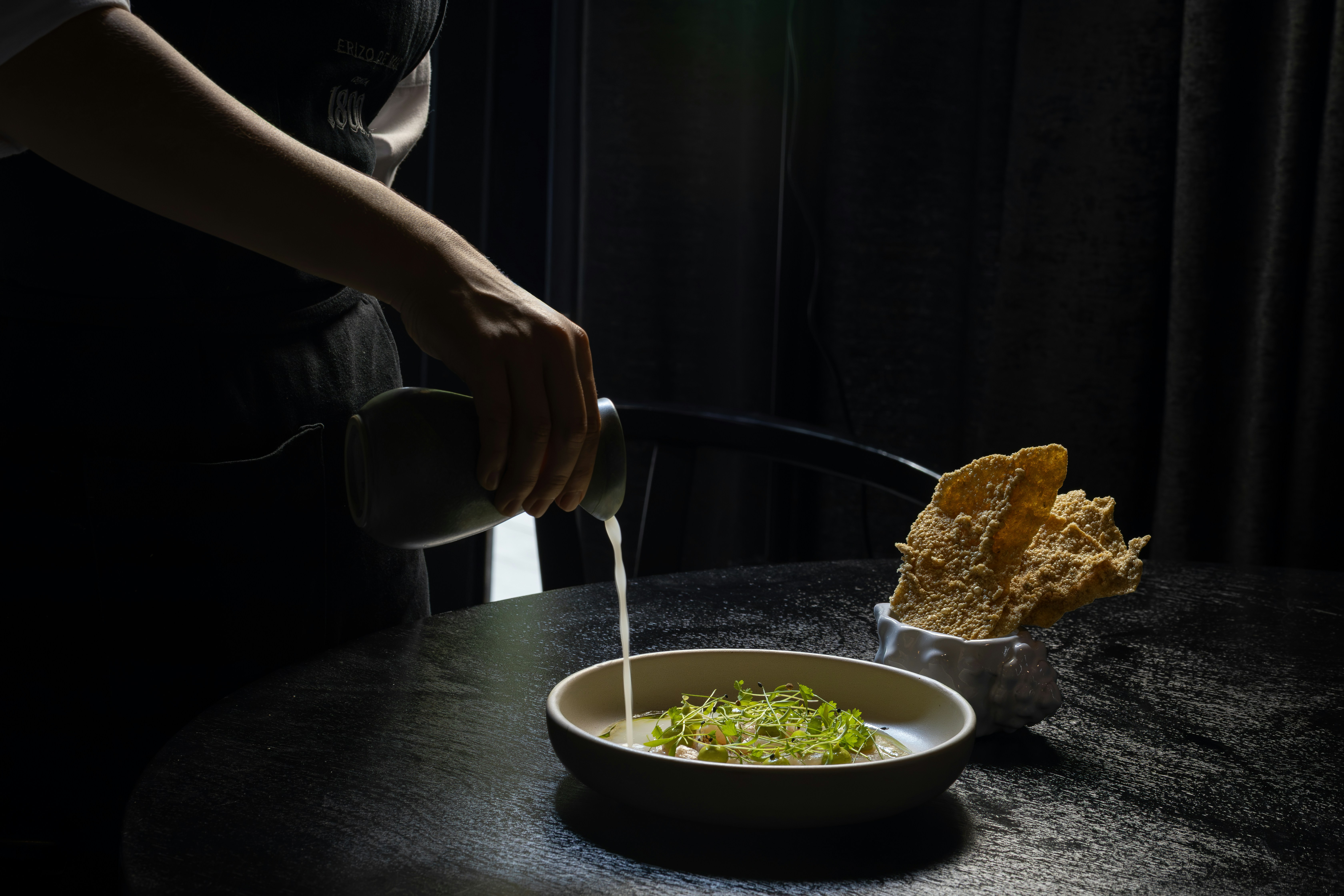 Chef plating a dish in a restaurant kitchen