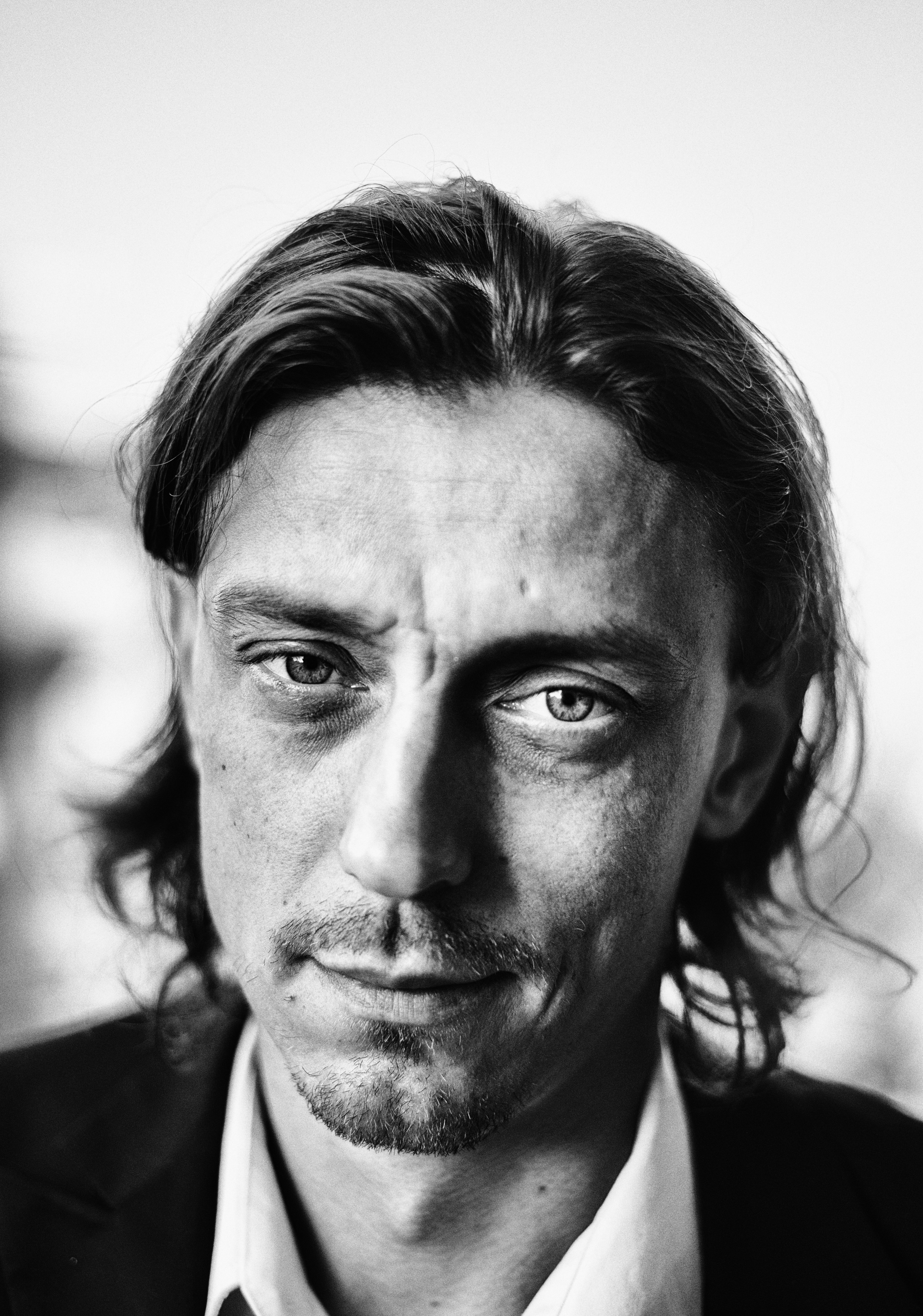 Black and white portrait of a man with long hair.