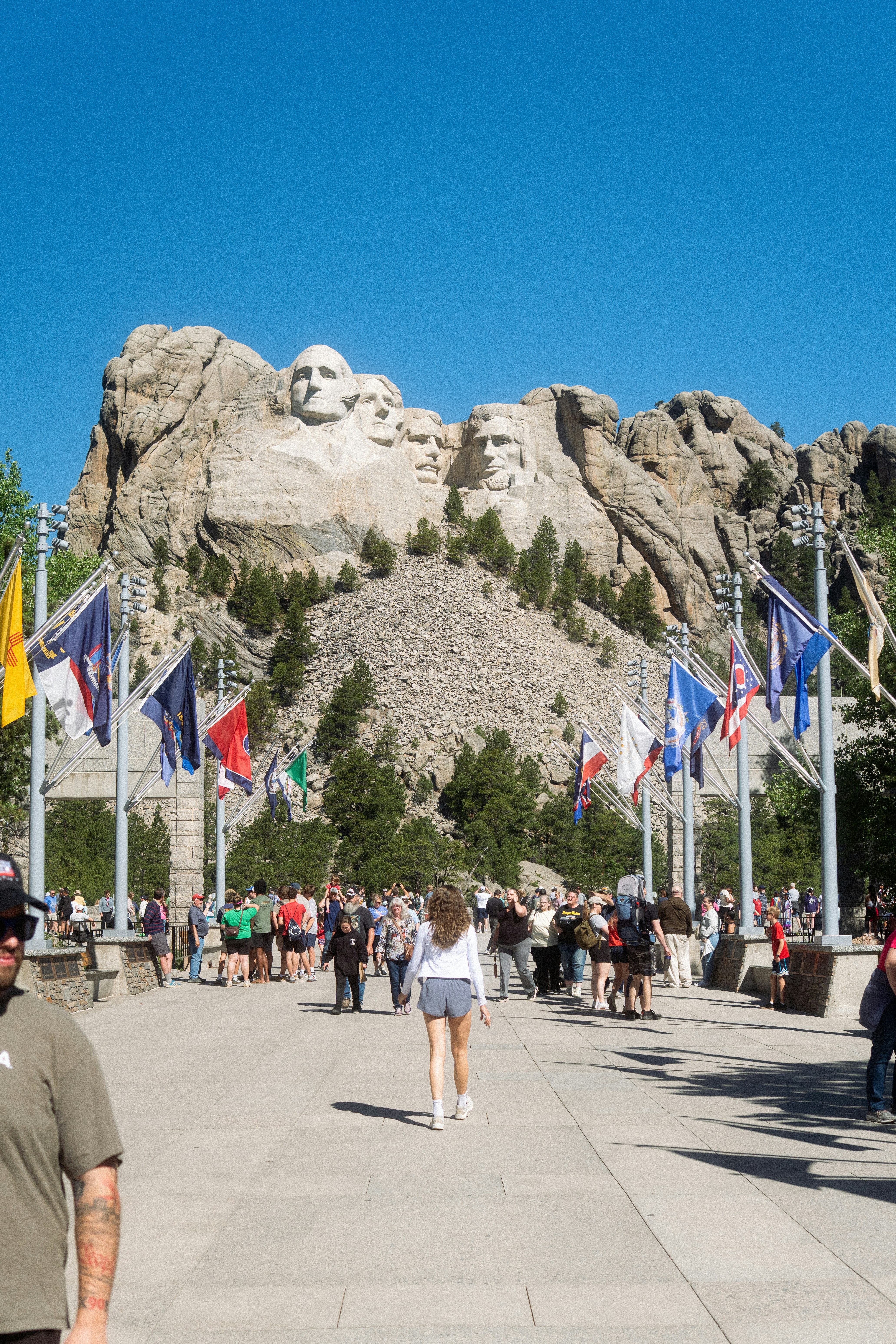 Mount rushmore monument with flags and visitors - presidential history sites