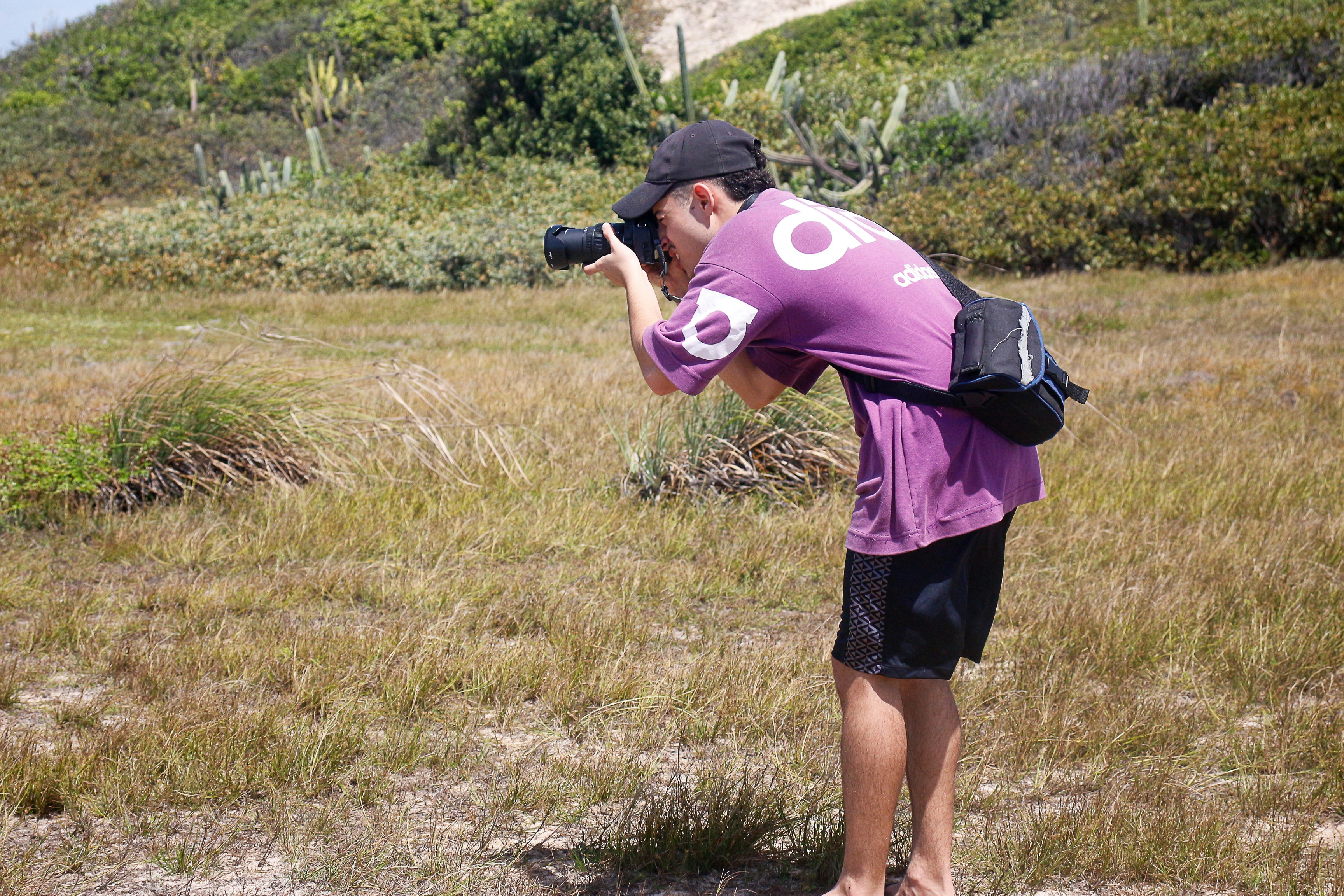 A person using a camera in a natural outdoor setting