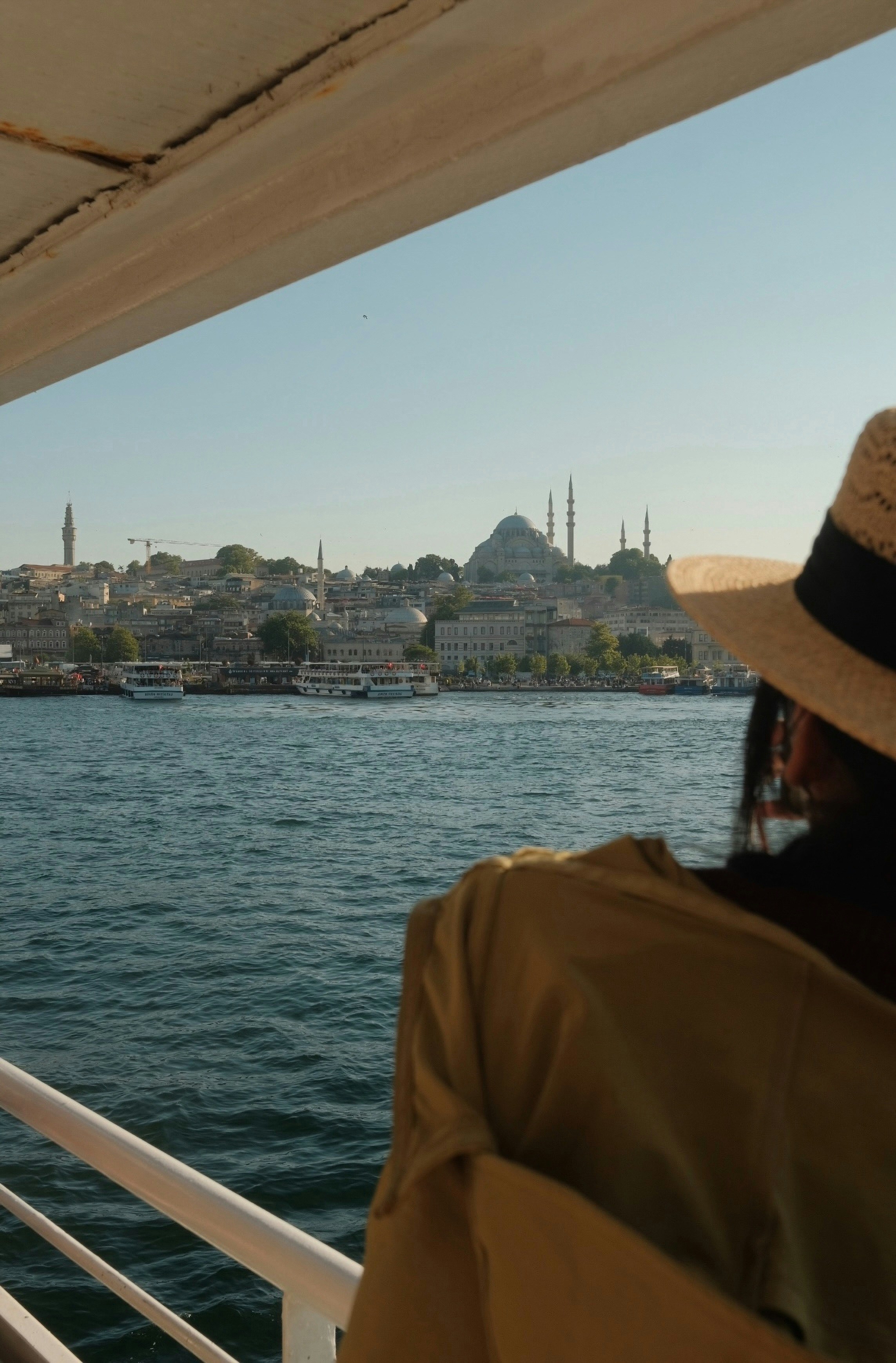 Frau auf dem Boot betrachtet die Skyline von Istanbul mit historischer Moschee