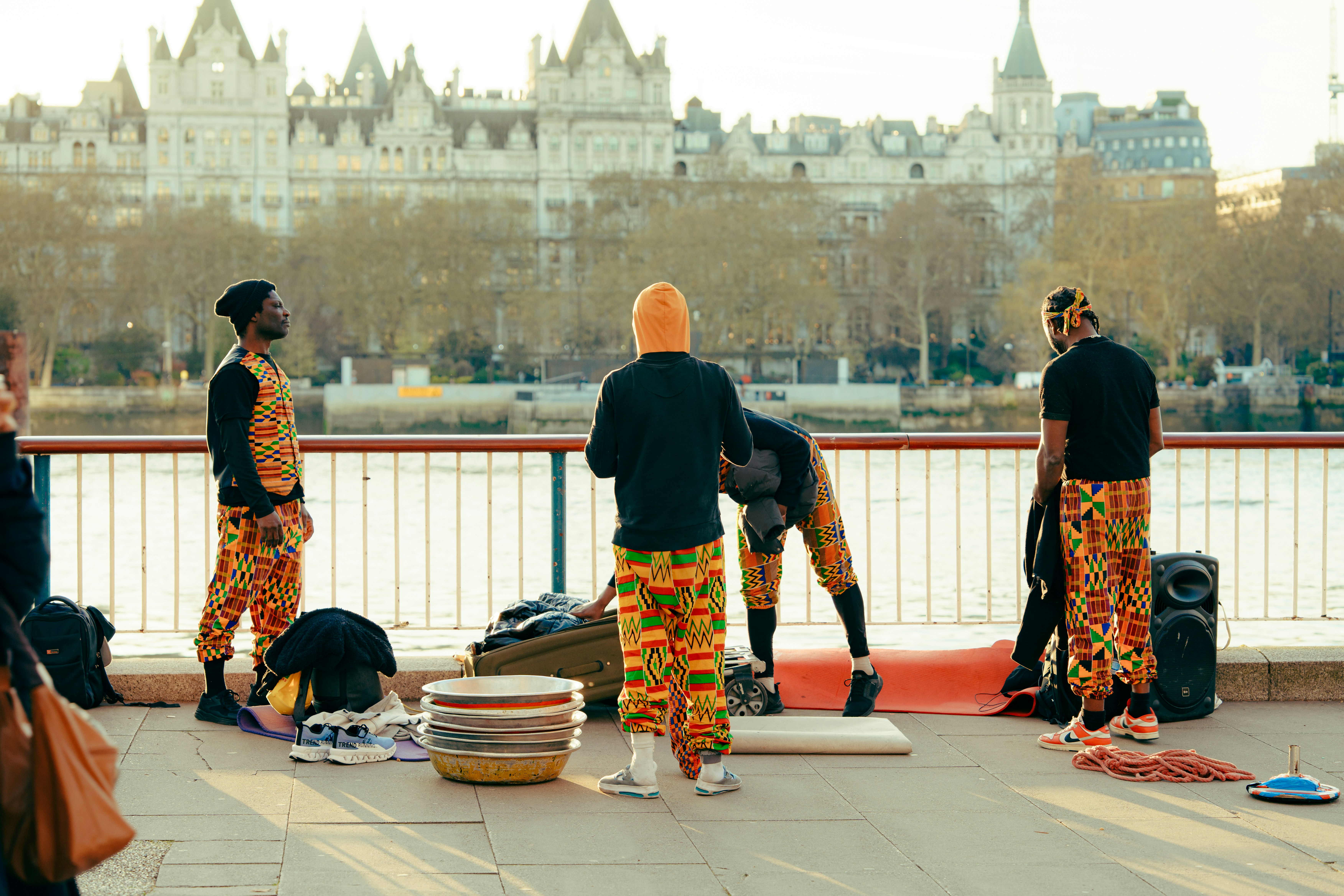 Men in vibrant patterned outfits performing on a city bridge