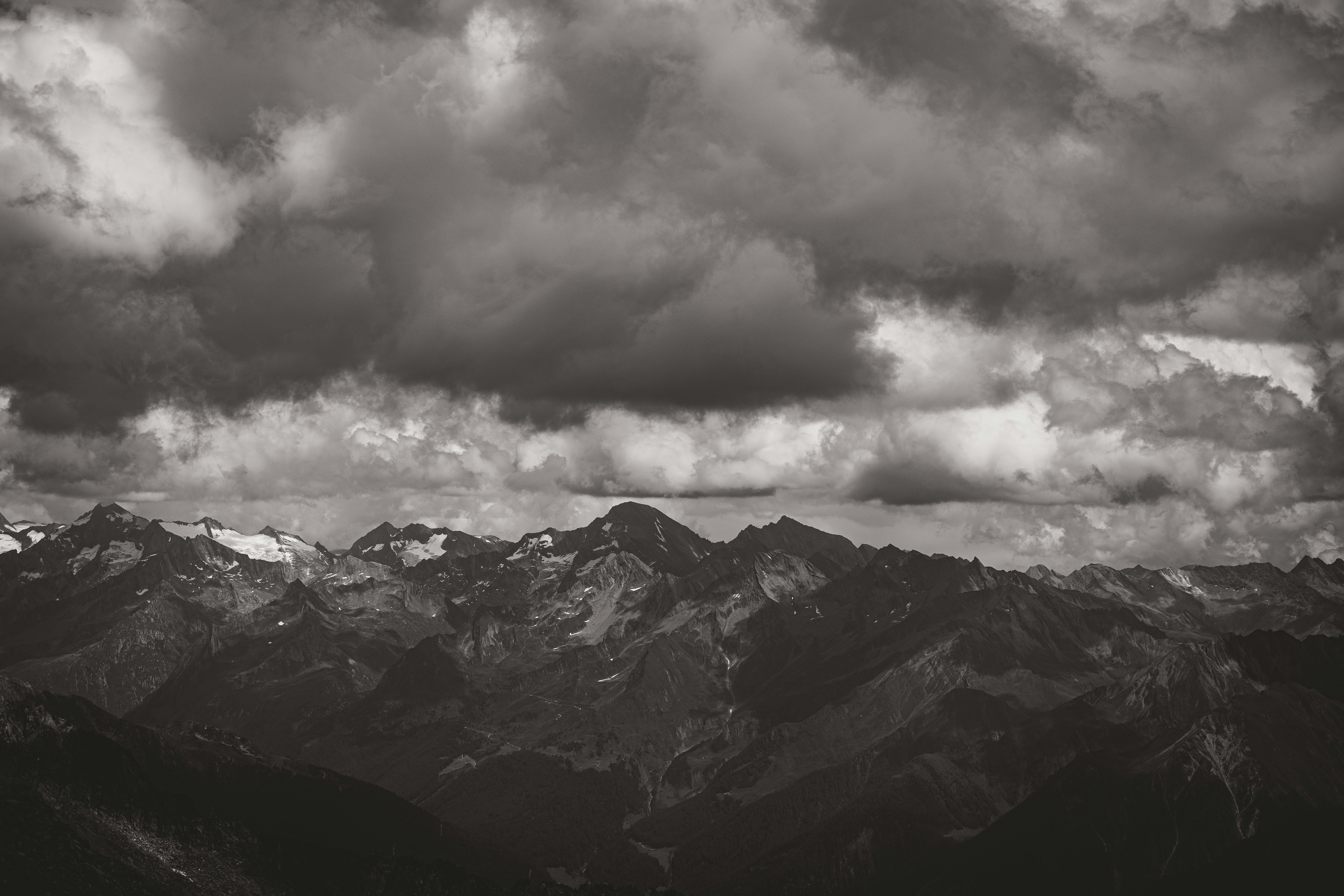 Dramatic cloudy skies over a rugged mountain range.