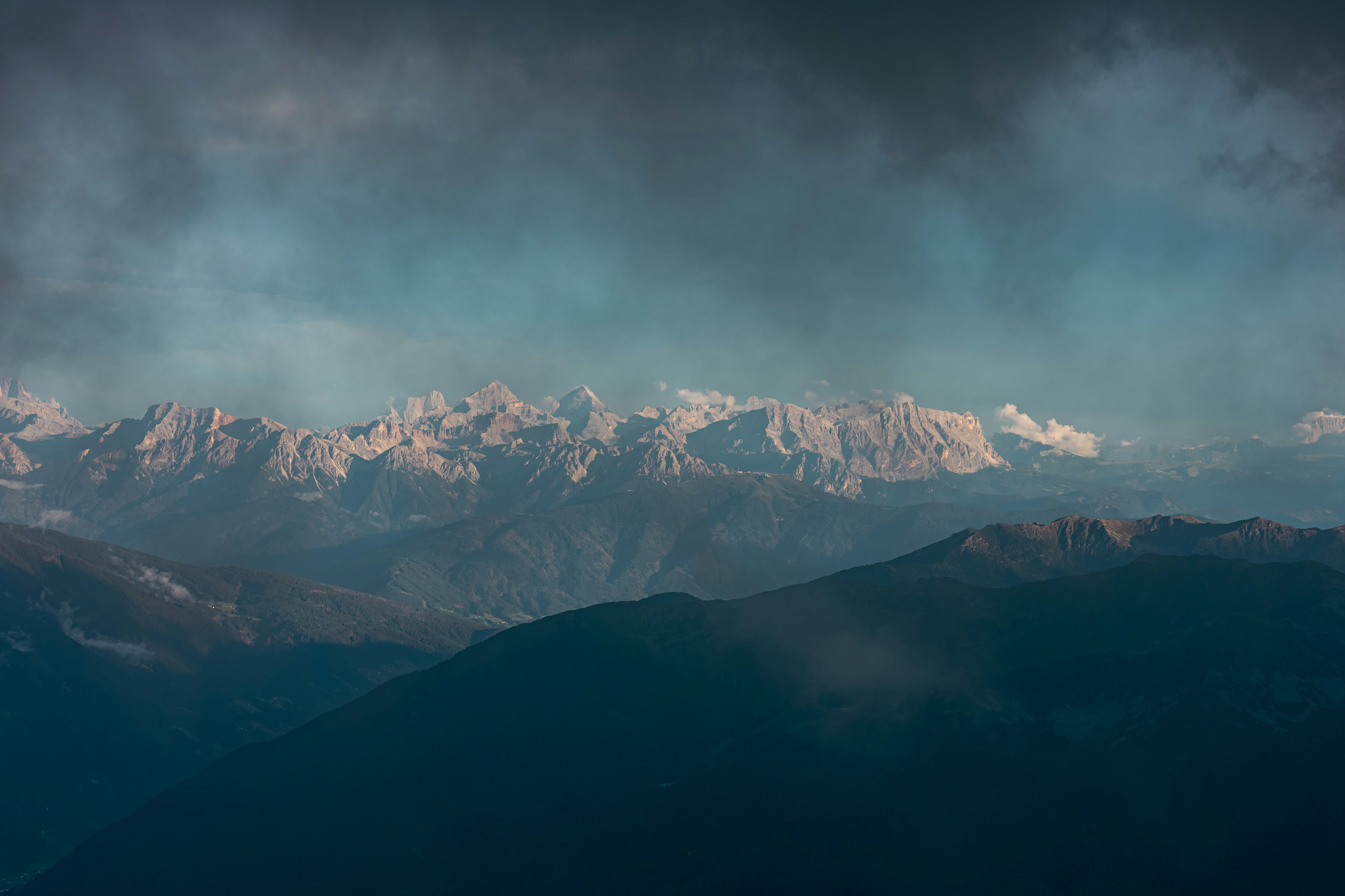 Majestic snow-capped mountains under a dramatic cloudy sky.