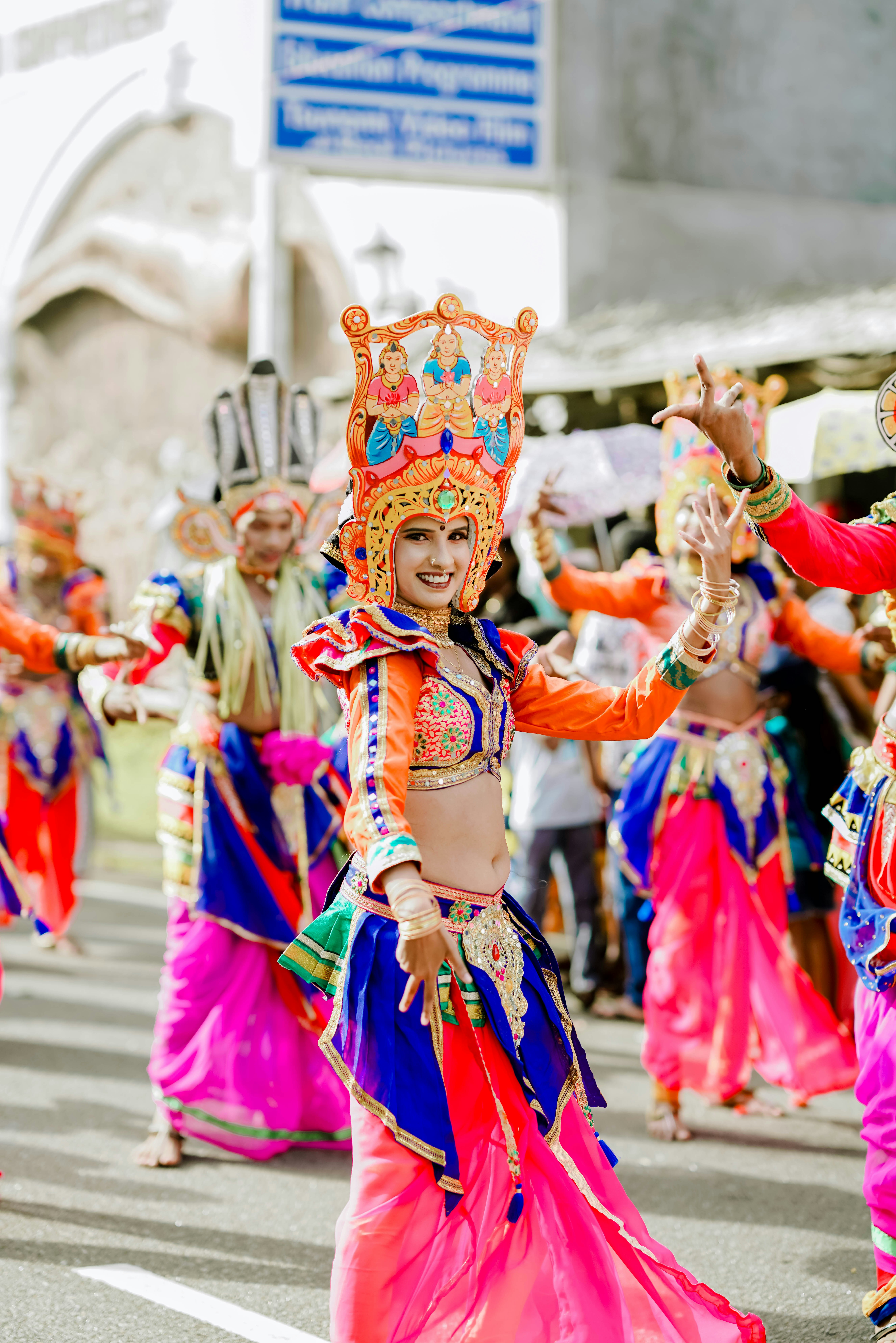 A woman in colorful traditional dress performs during a festival.