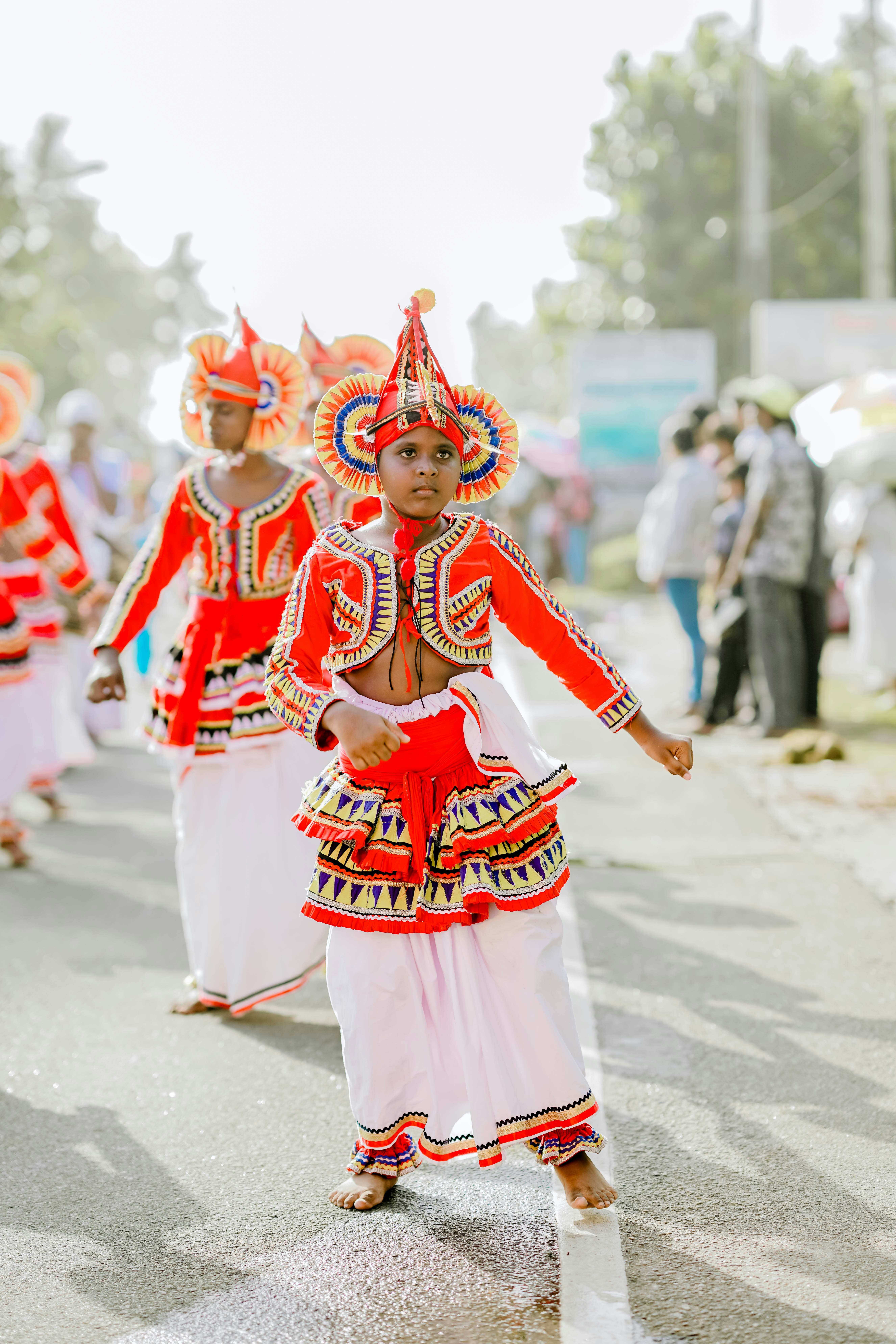 Young performer in elaborate traditional attire dancing outdoors.
