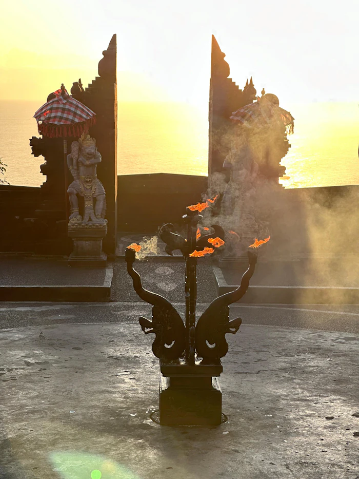 Opferschale mit Flammen vor einer balinesischen Tempelfigur