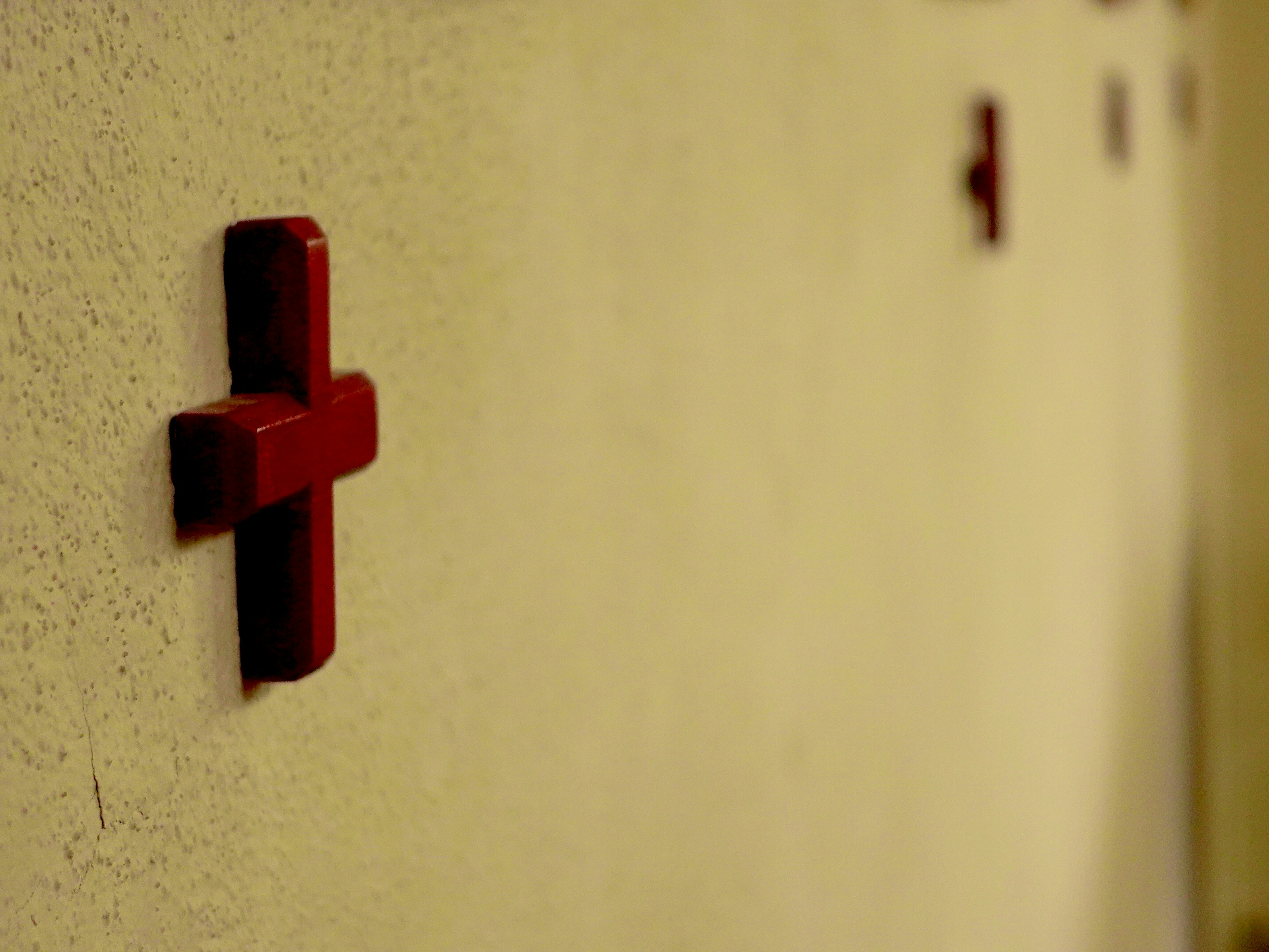 Rotkreuzsymbole an einer strukturierten beigen Wand.