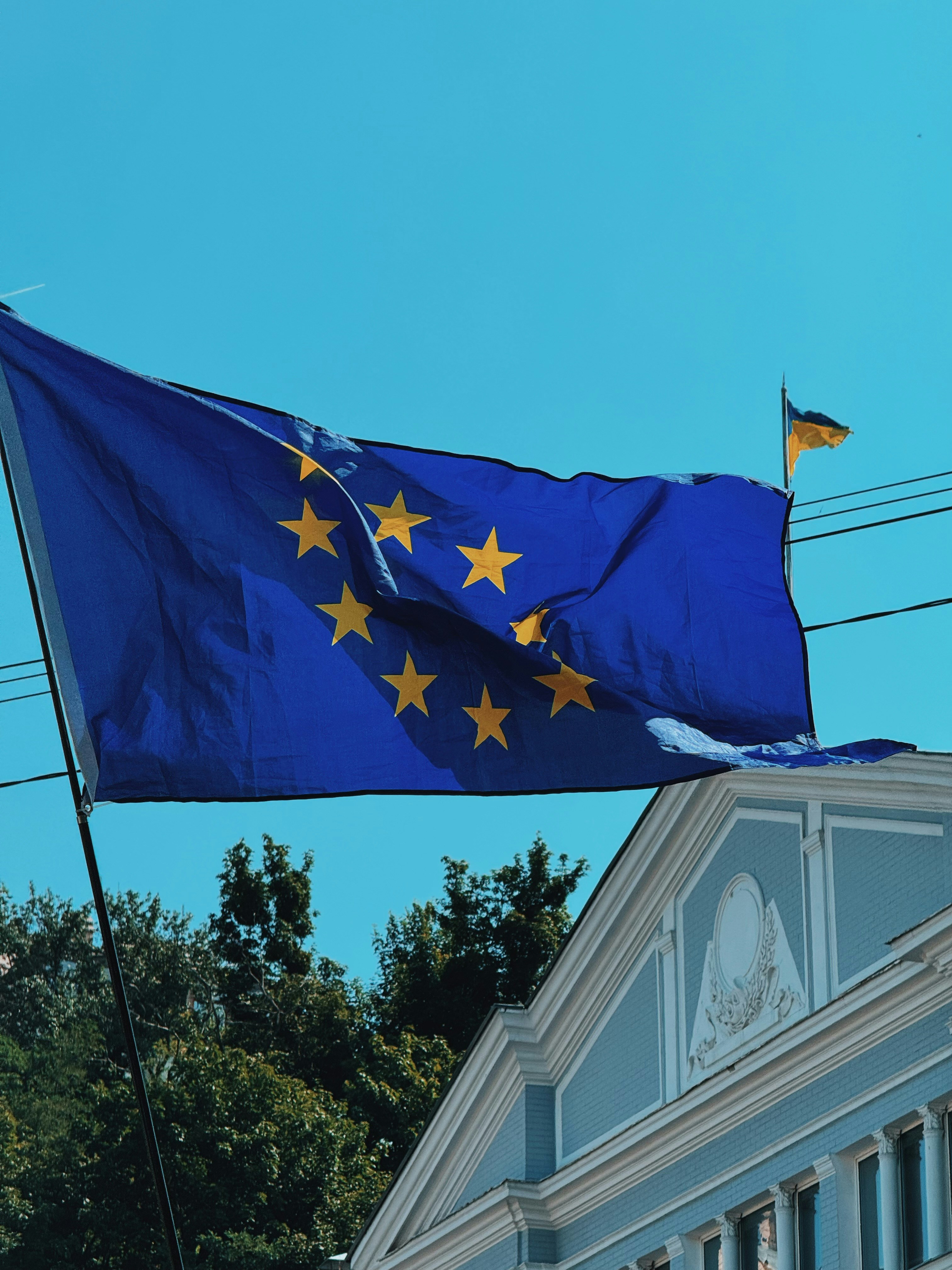 European union flag flying above a building under blue sky