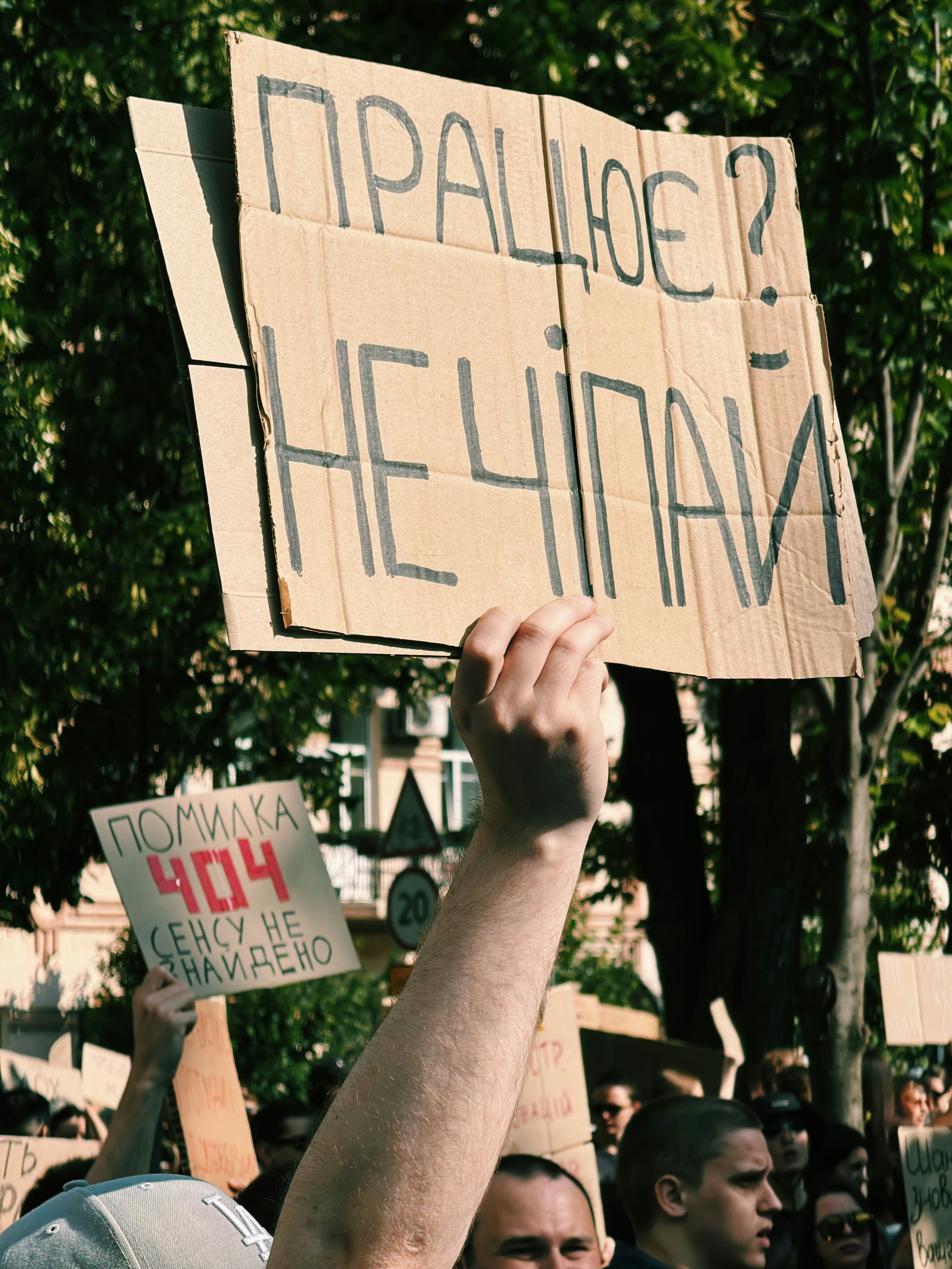 People holding protest signs with ukrainian text