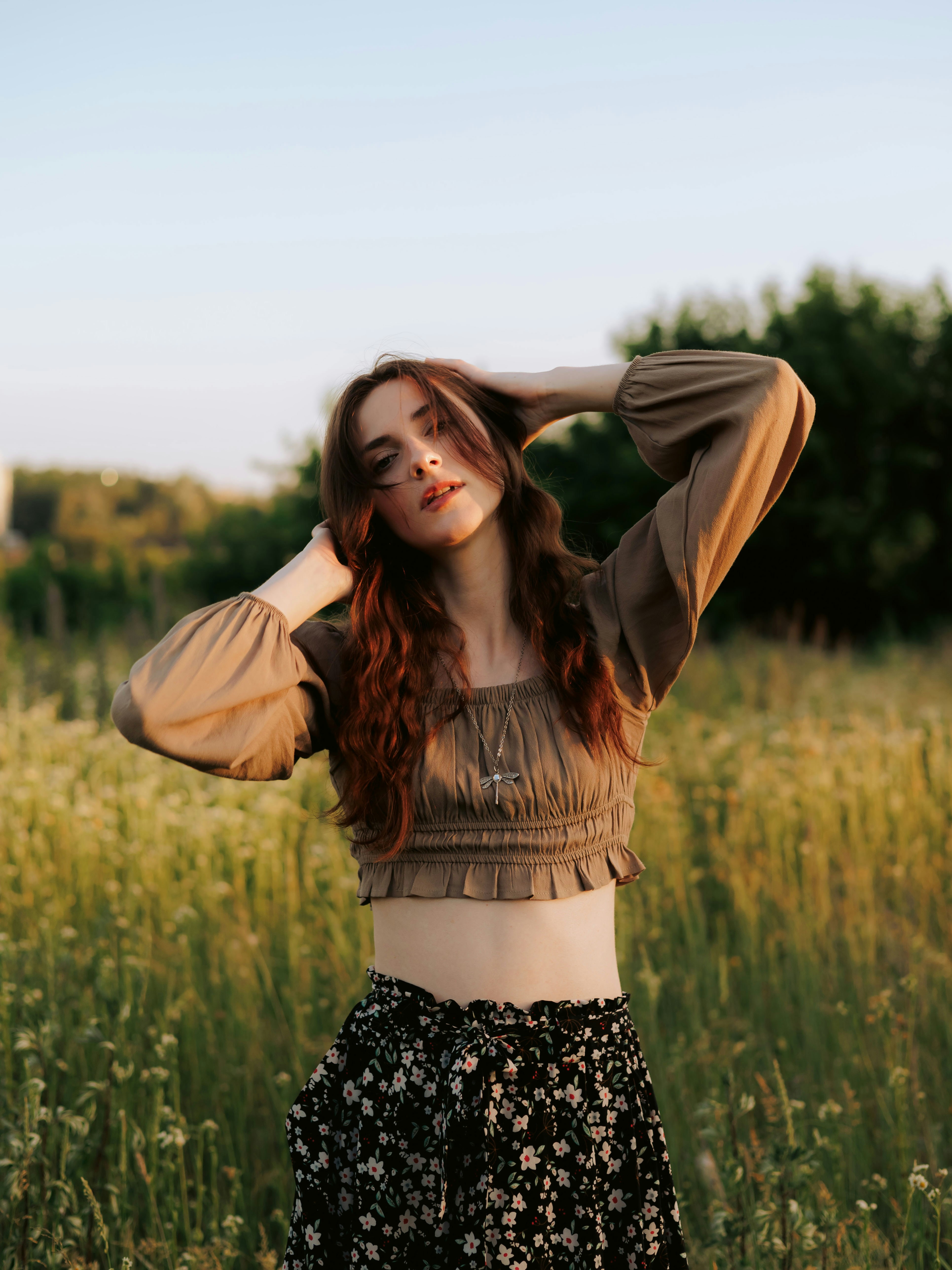 Rothaarige Frau auf einem Feld zur goldenen Stunde.
