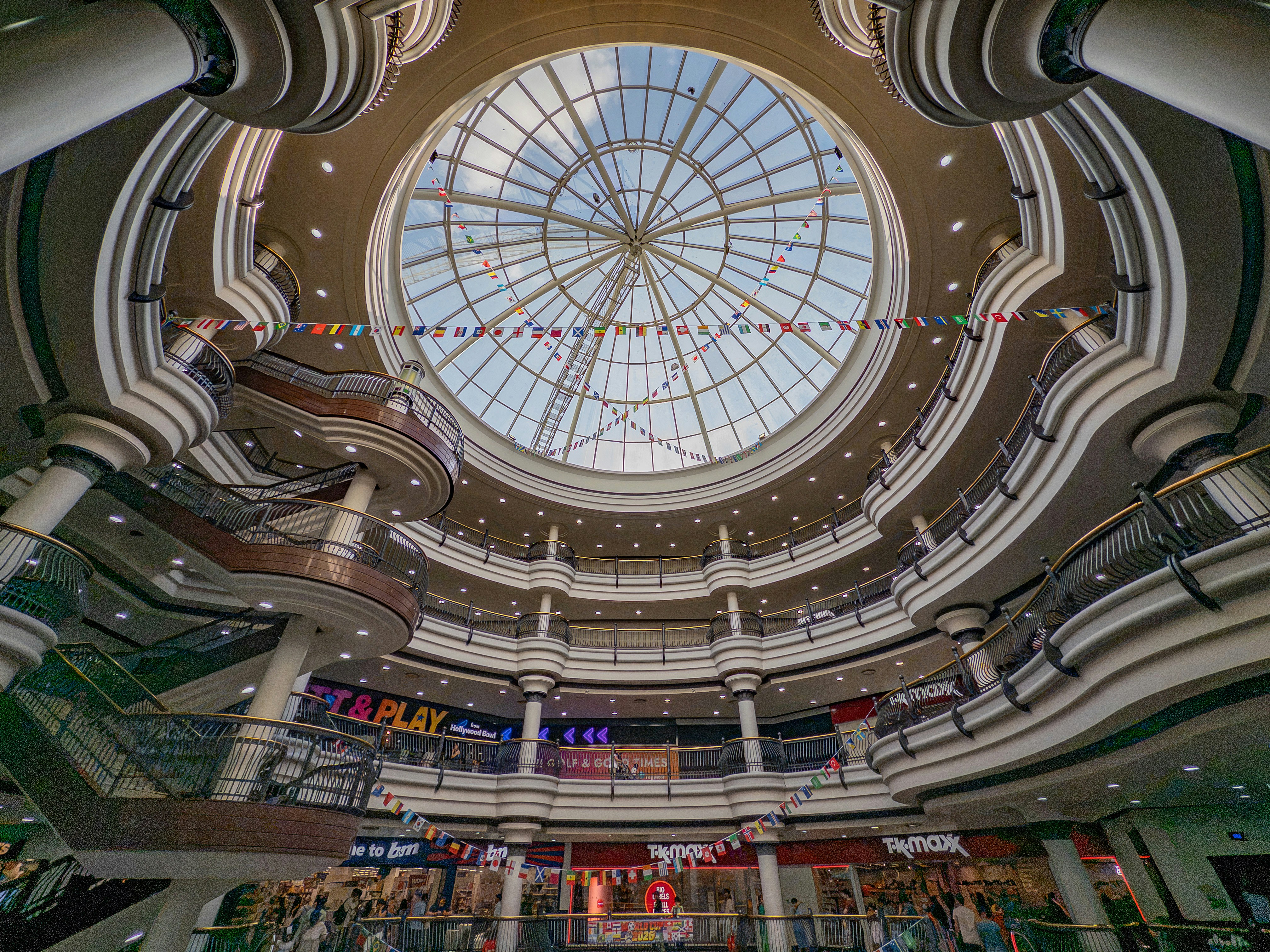 Interior of a multi-story shopping mall with a glass dome.