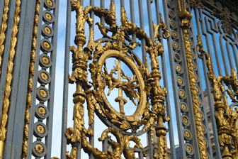 Ornate gold and dark metal gate with elaborate details