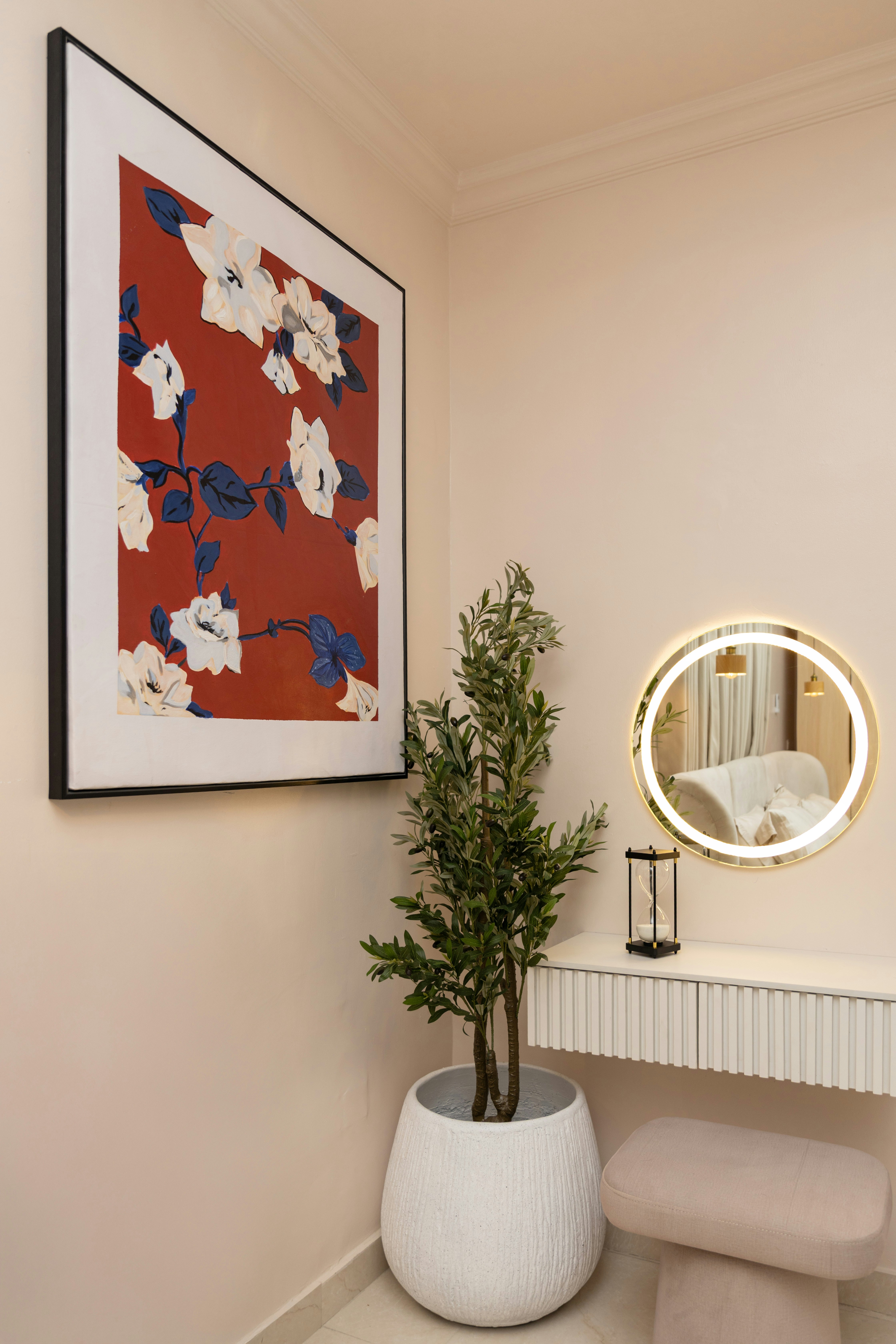 A bright dressing corner with a lit round mirror and a plant
