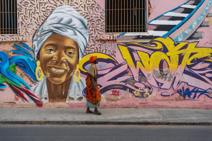 A person walks past a vibrant street art mural