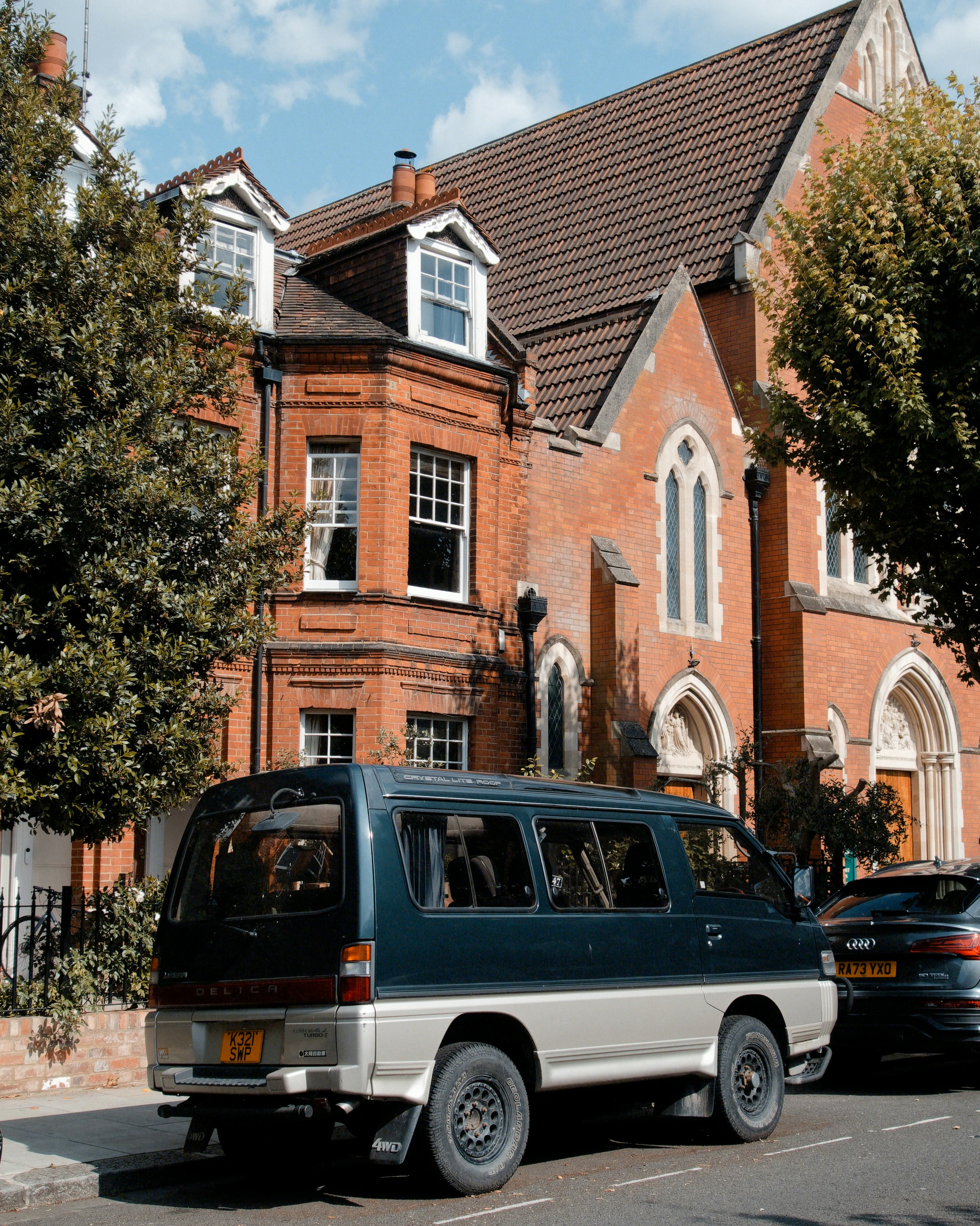 A two-tone van parked on street by red brick building