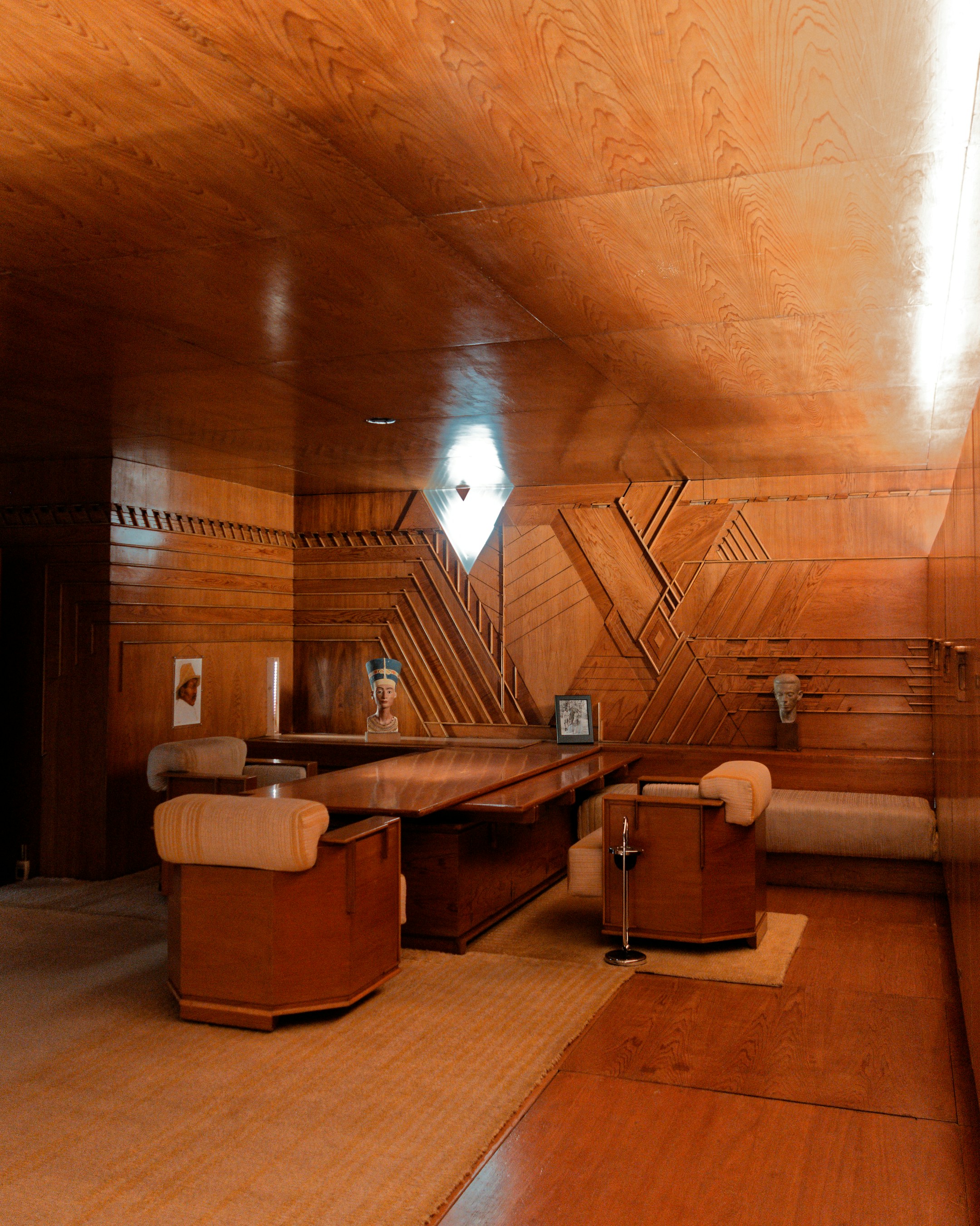Ornate wooden office interior with a desk and chairs