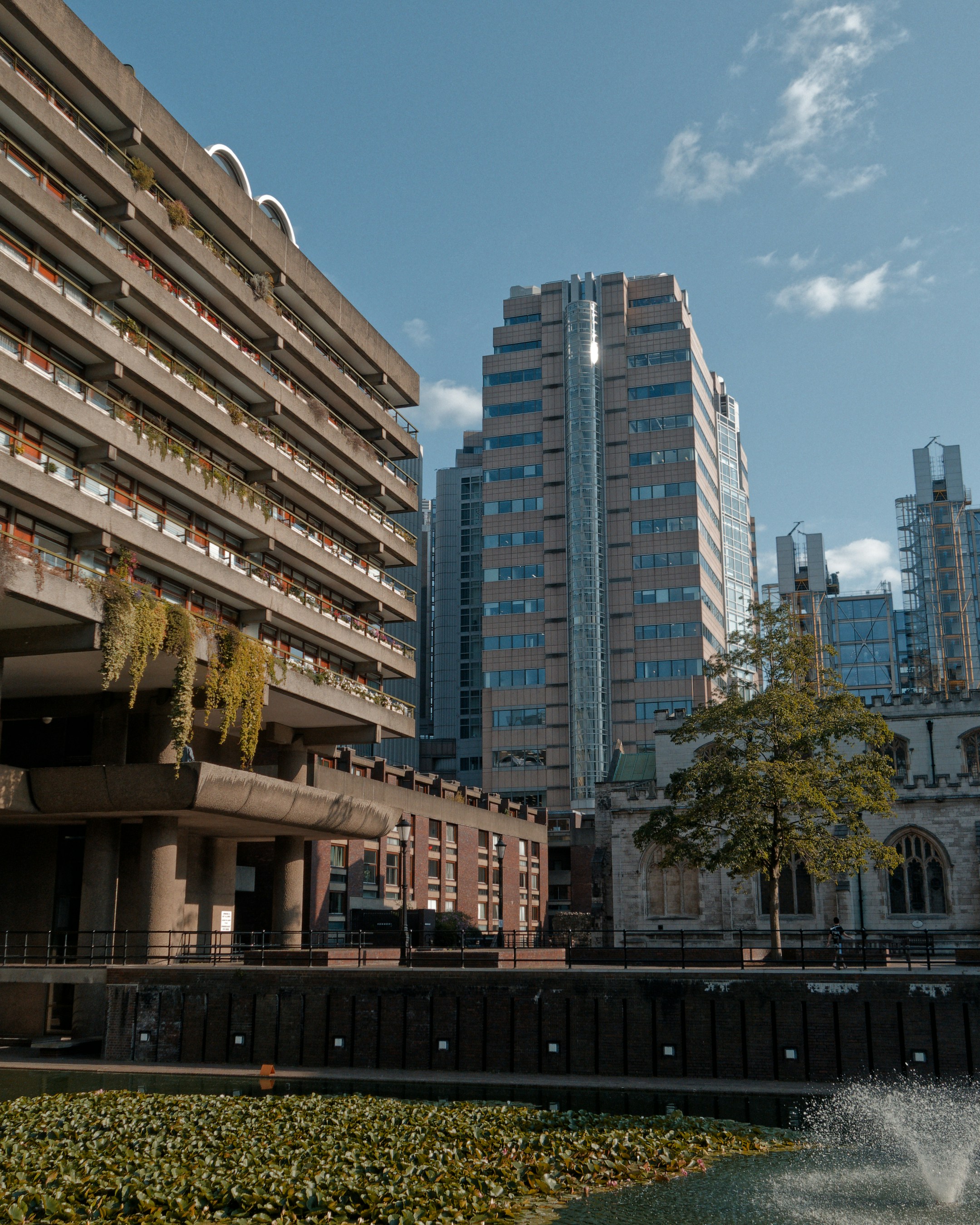 Concrete brutalist architecture, modern skyscraper, and historic church with water