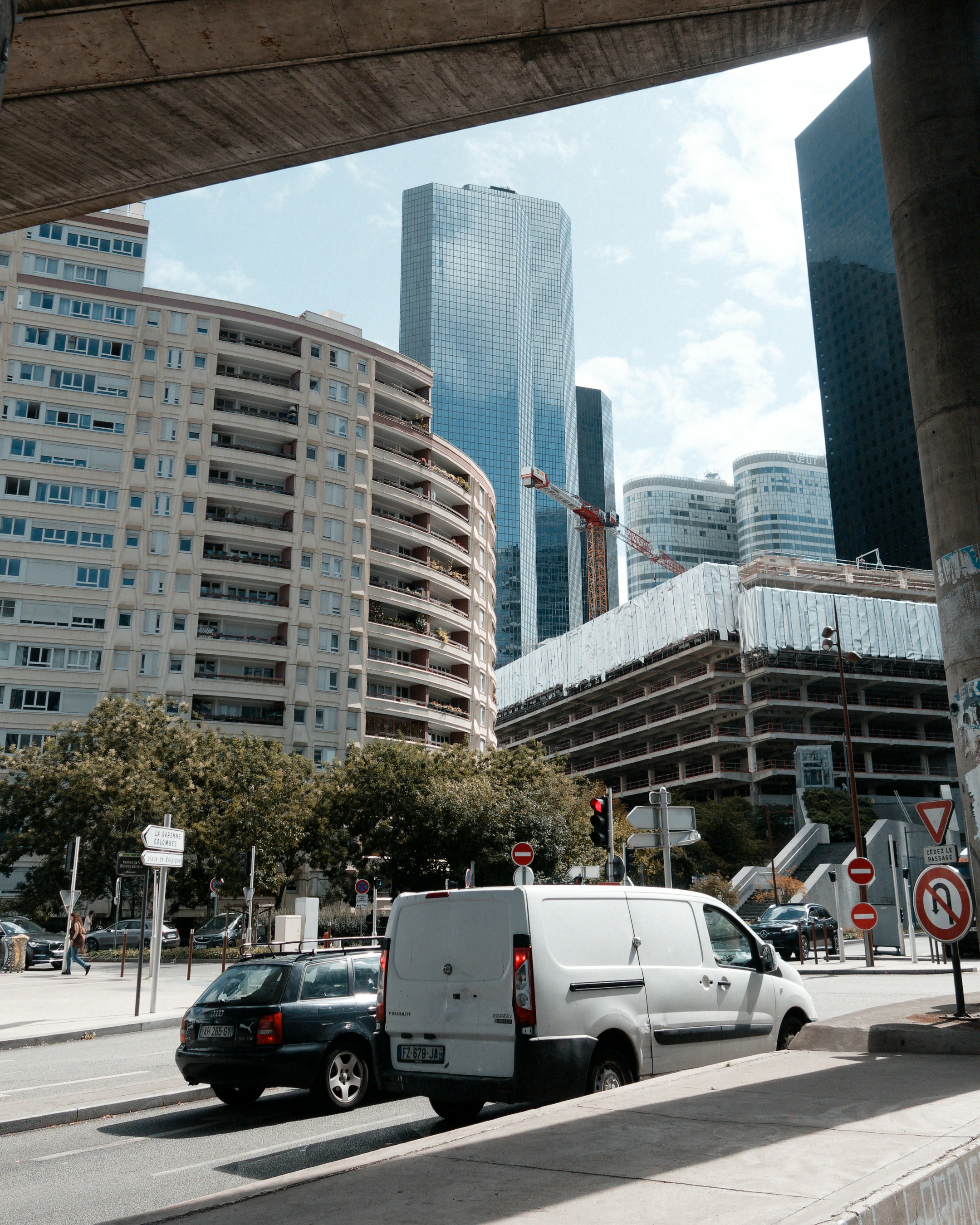 Urban street scene with modern buildings, cars, and clear sky