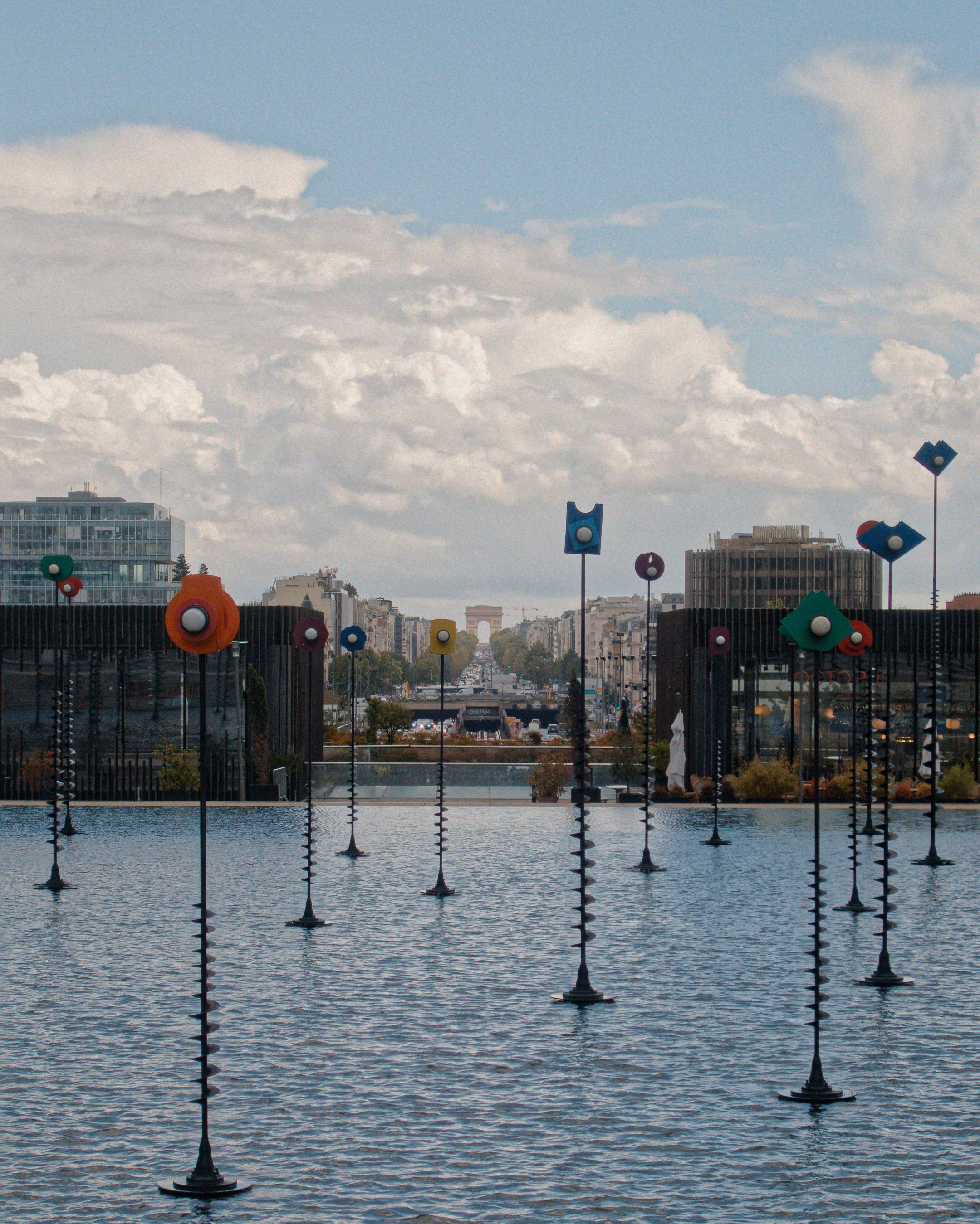 Colorful art installations in a water basin, arc de triomphe