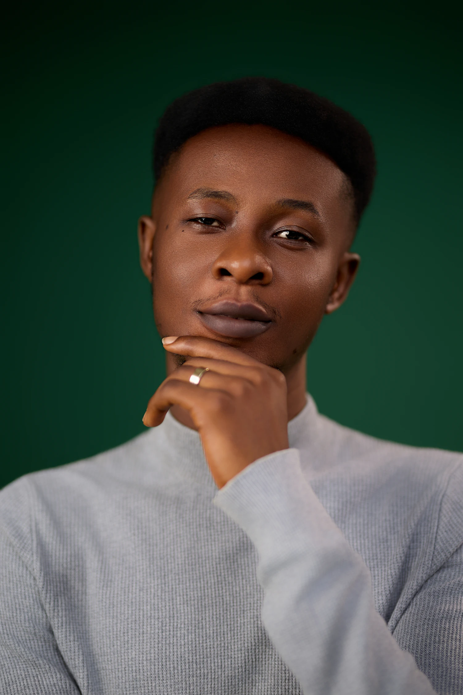 Teodor Mlynar in a grey roll-neck against a deep green ground