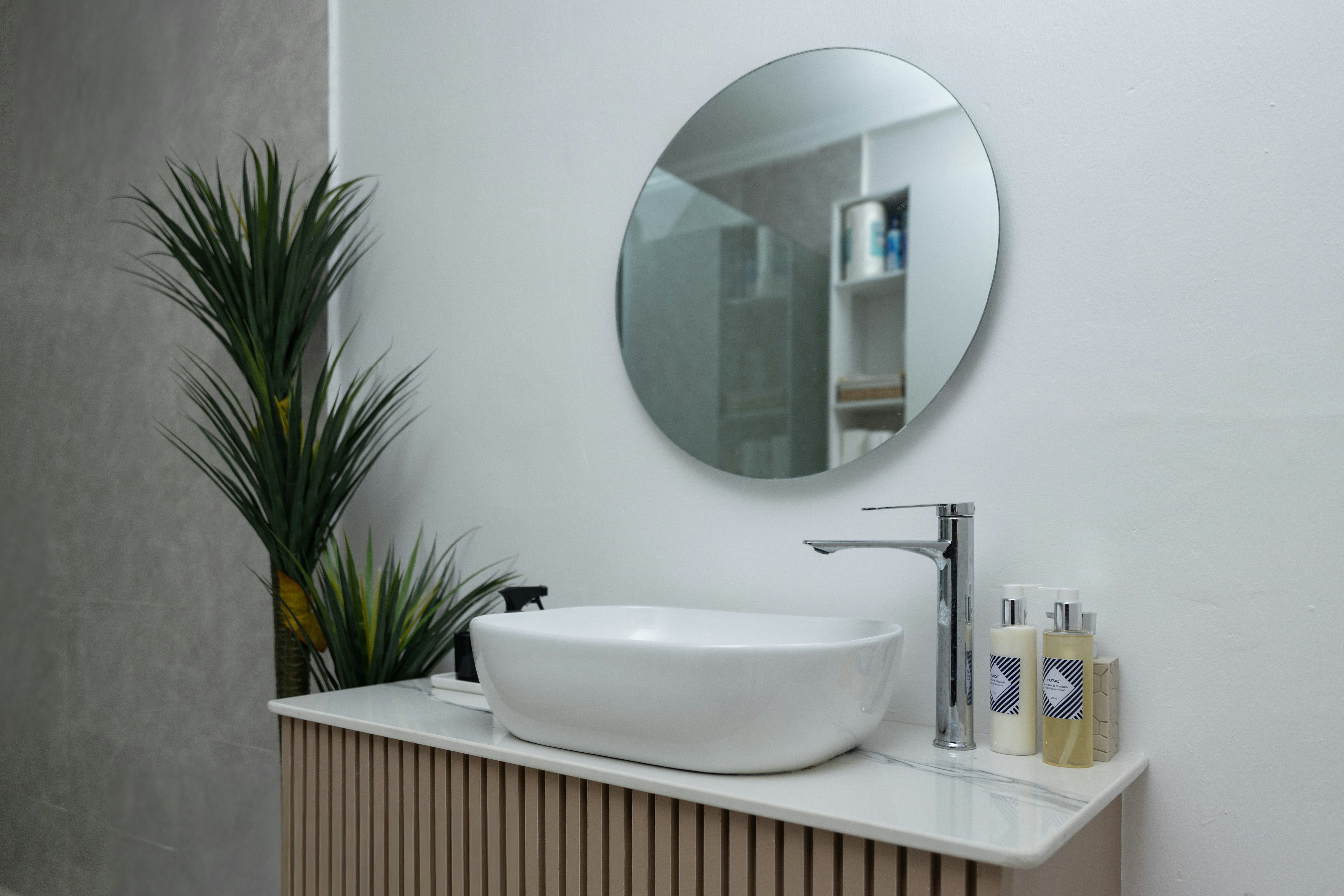 Luxury modern architectural bathroom setup with minimal vanity, marble top, and dynamic natural light