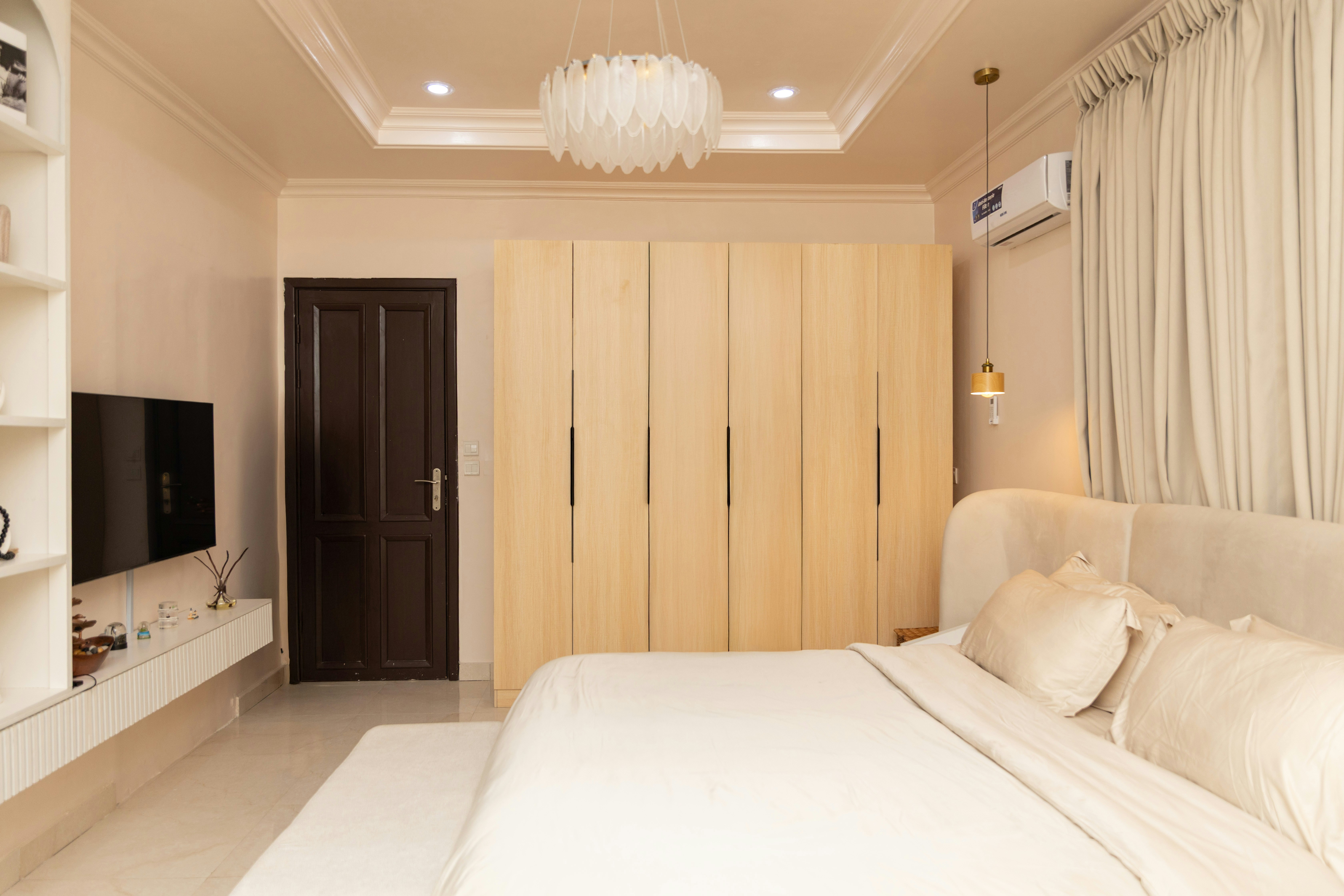 Un dormitorio moderno con cama, armarios y televisión.