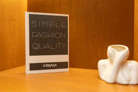 White ceramic object next to "simple fashion quality" sign.
