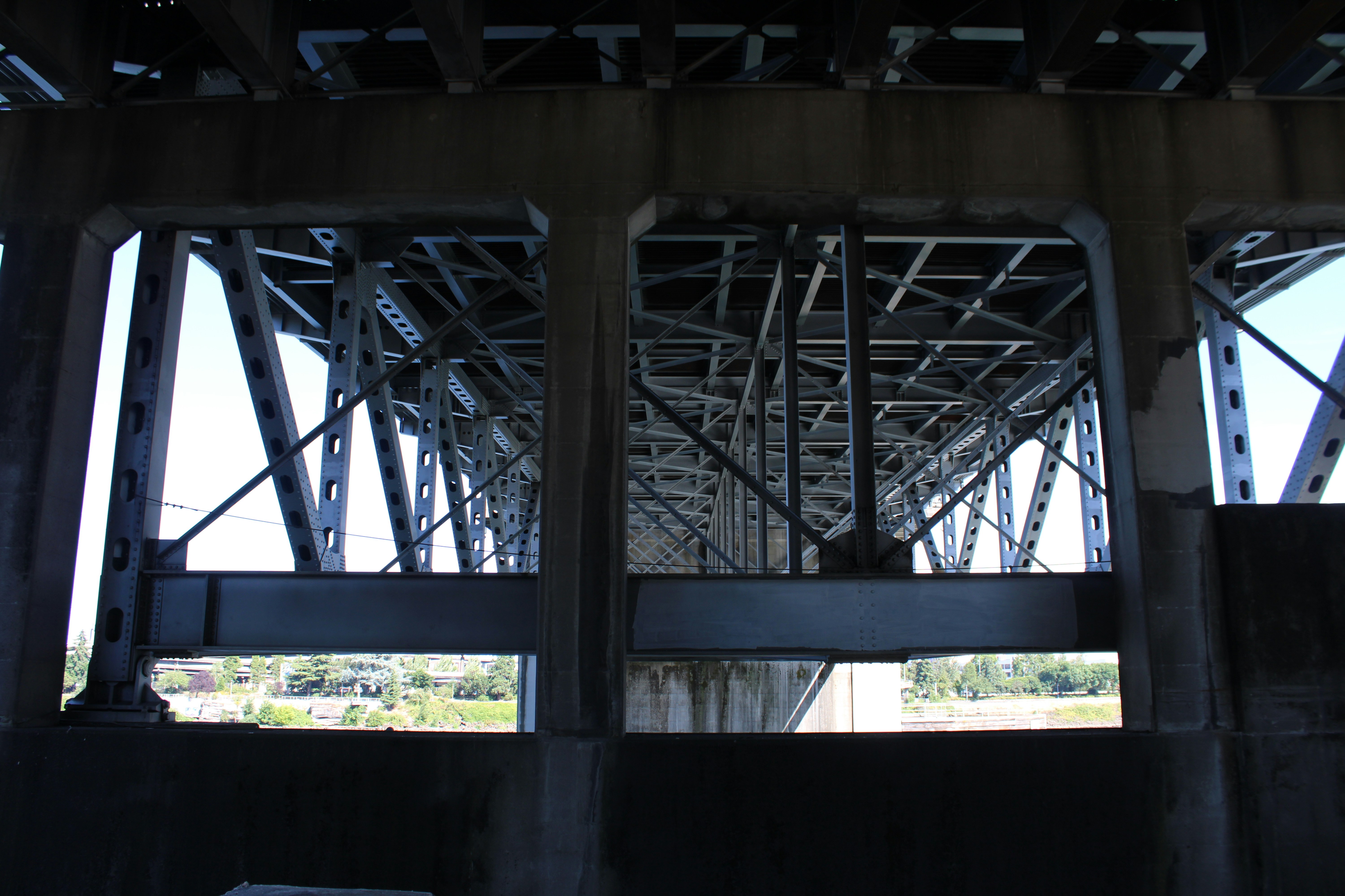 Steel and concrete bridge structure viewed from underneath.