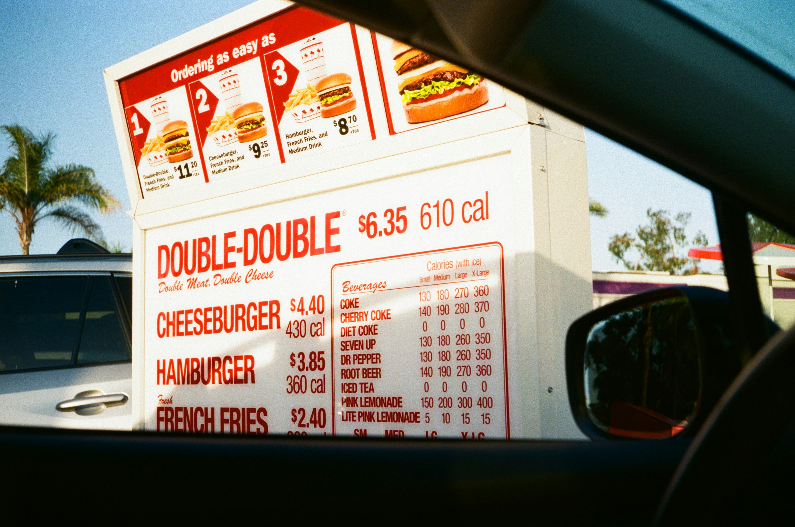 A drive-thru menu board viewed from inside a car