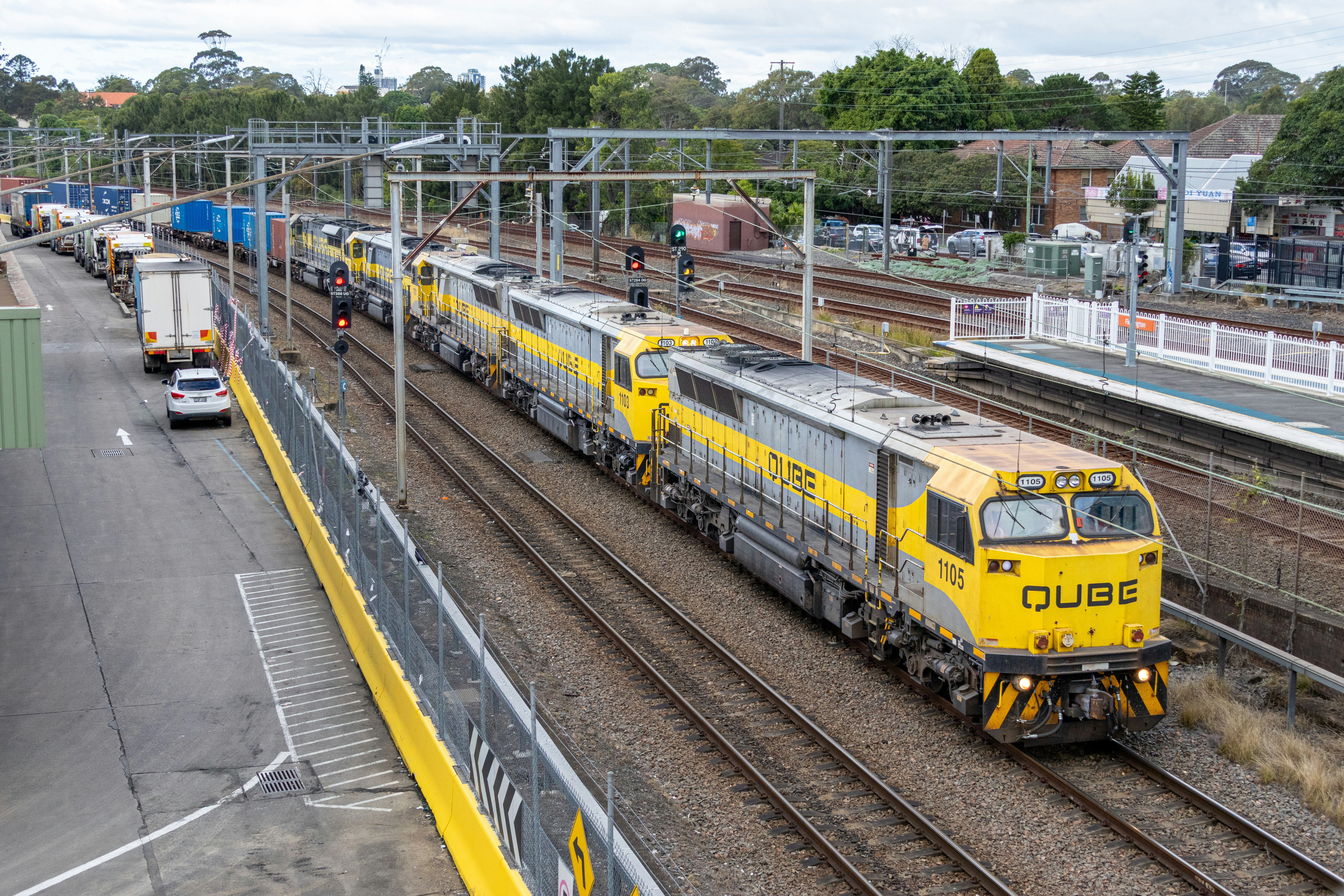 Yellow and grey train on tracks at a station.