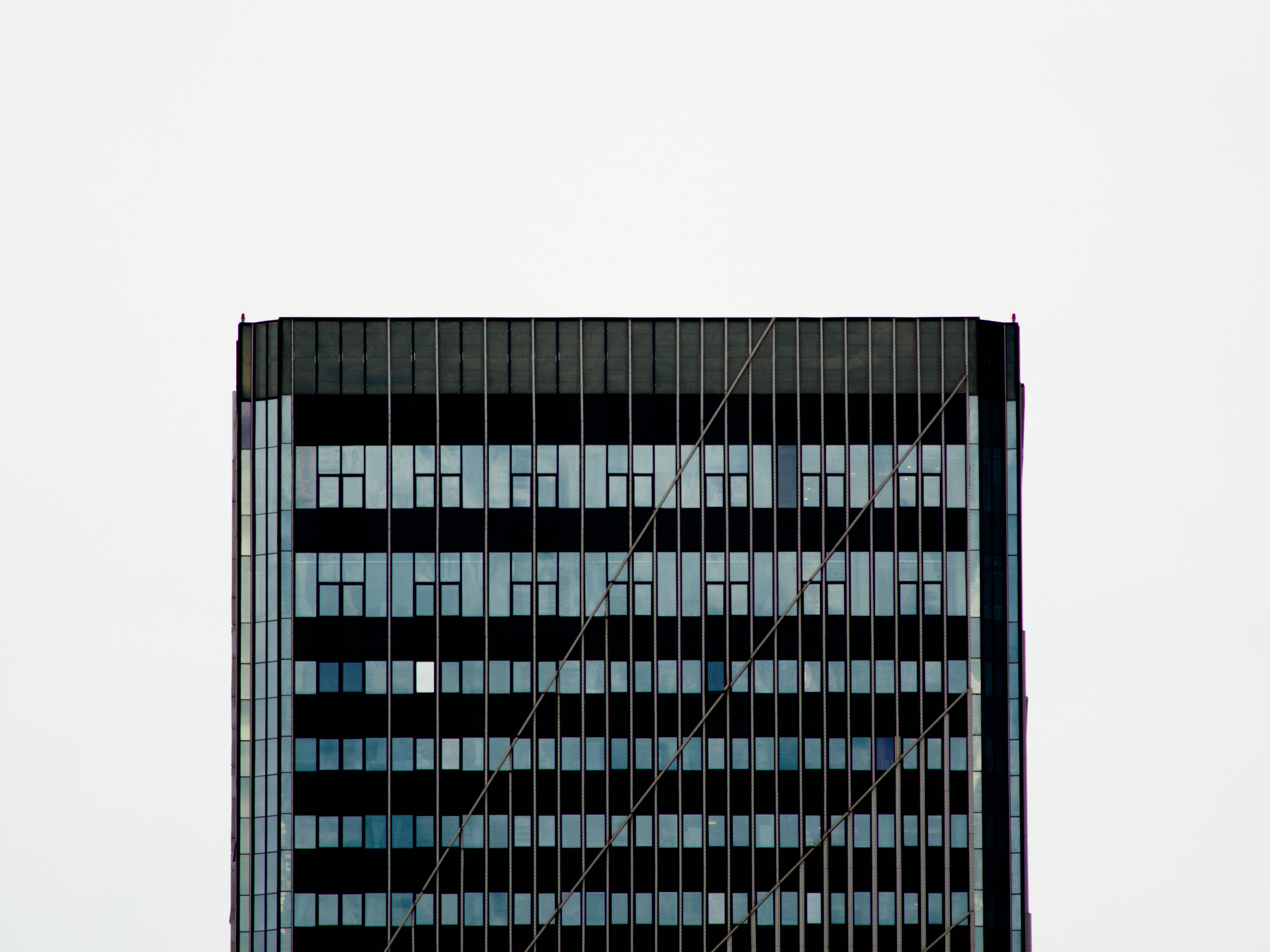Modern skyscraper with numerous windows against a bright sky