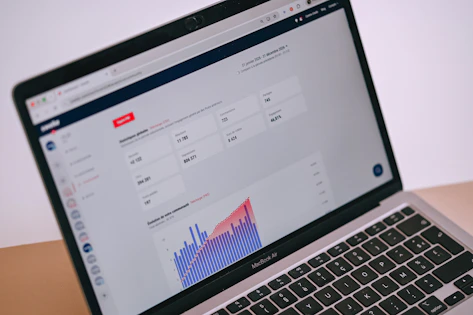 A laptop screen displays data analytics, charts, and statistics