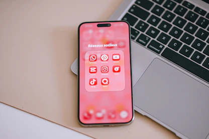 A smartphone displaying social media apps on a pink screen