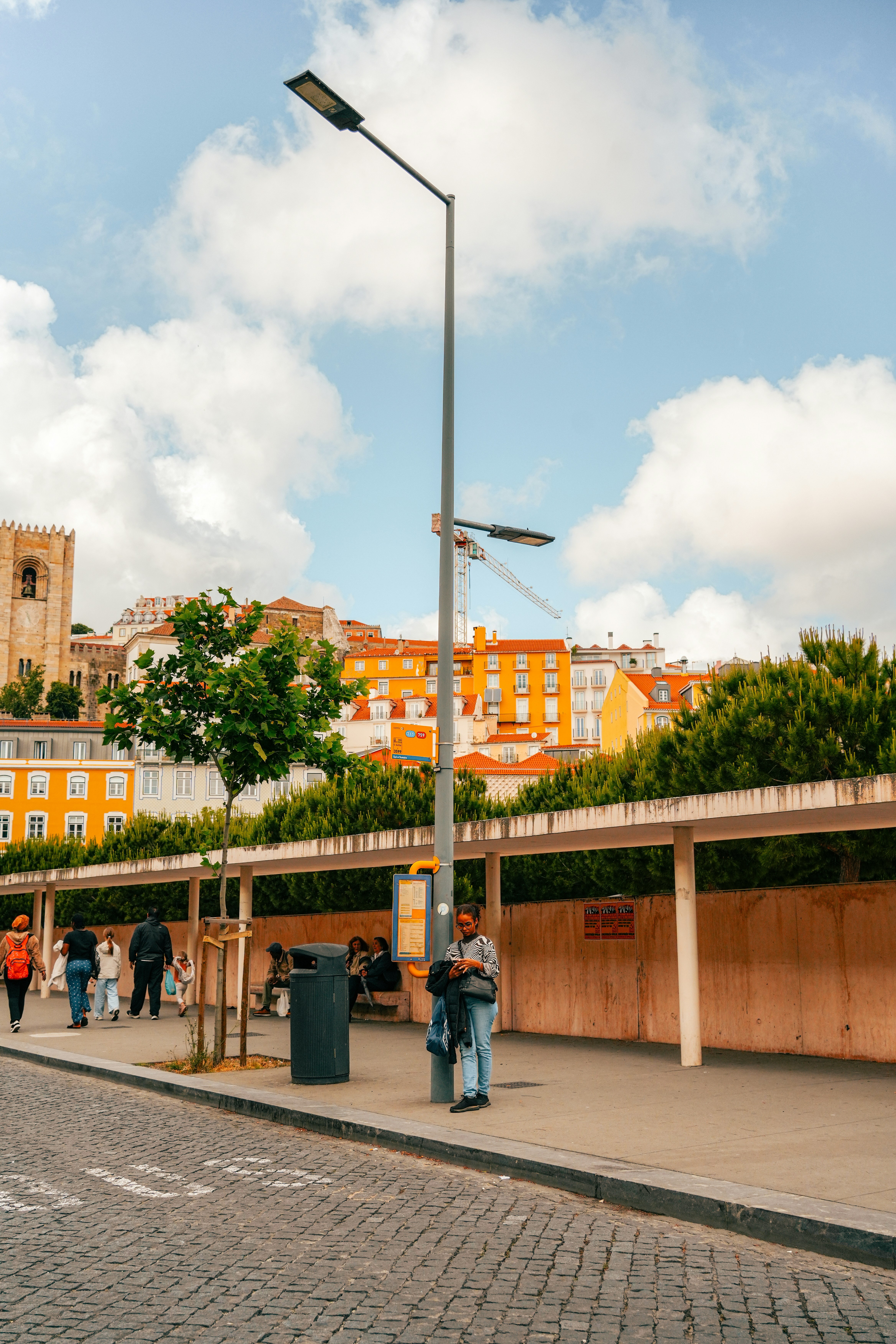 Urban street scene with pedestrians, lamppost, and colorful buildings