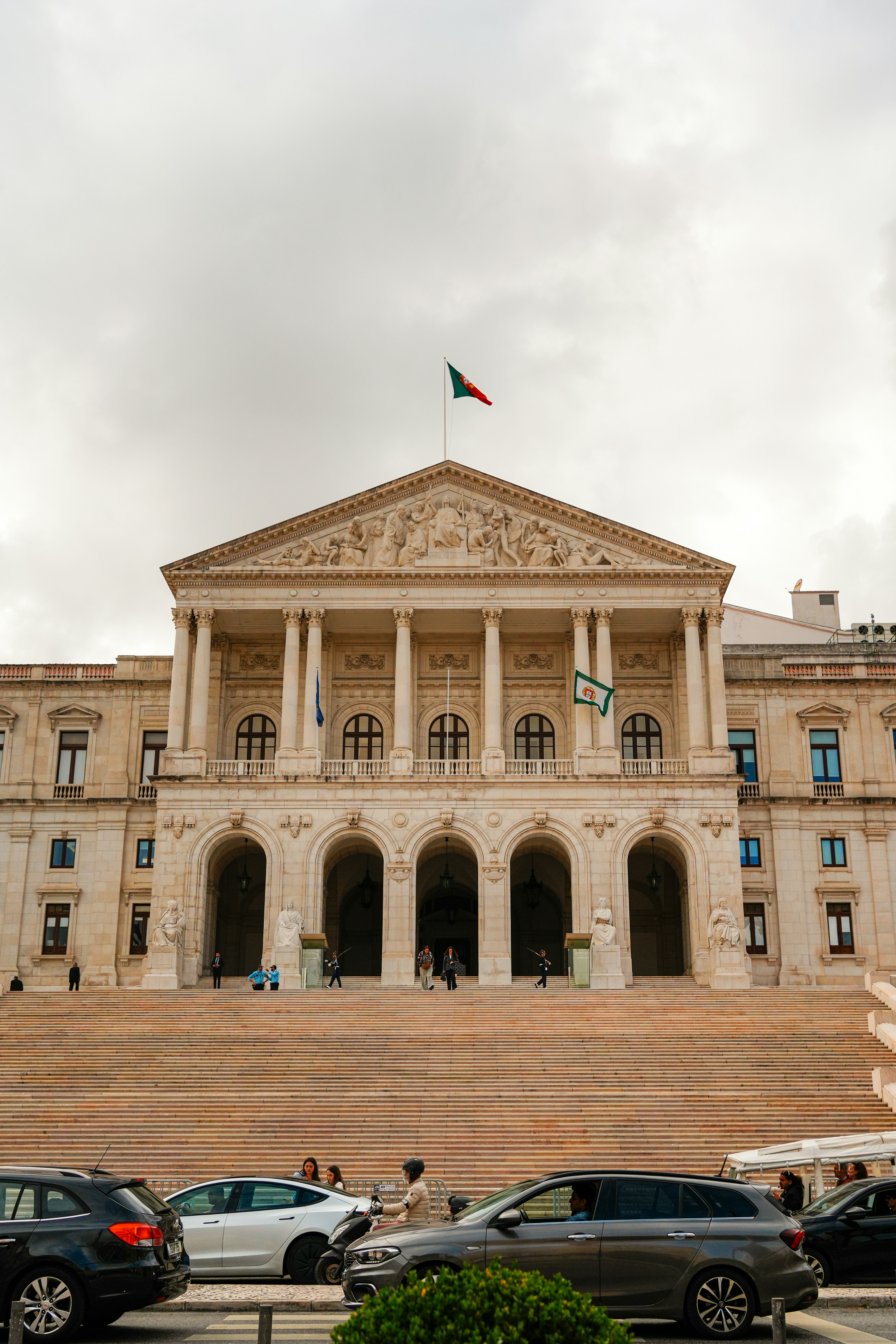 Historic building with columns, flag, and grand staircase