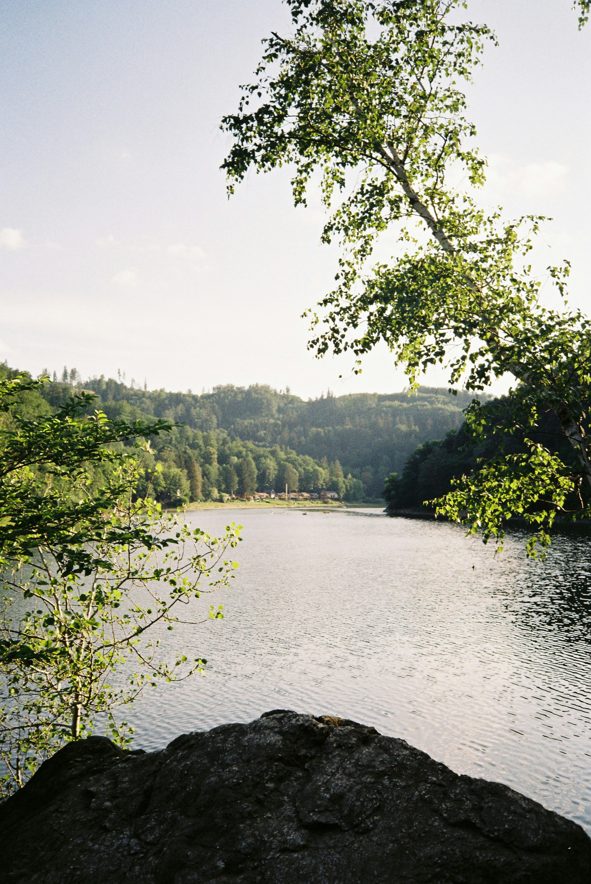 A serene lake surrounded by lush green hills and trees