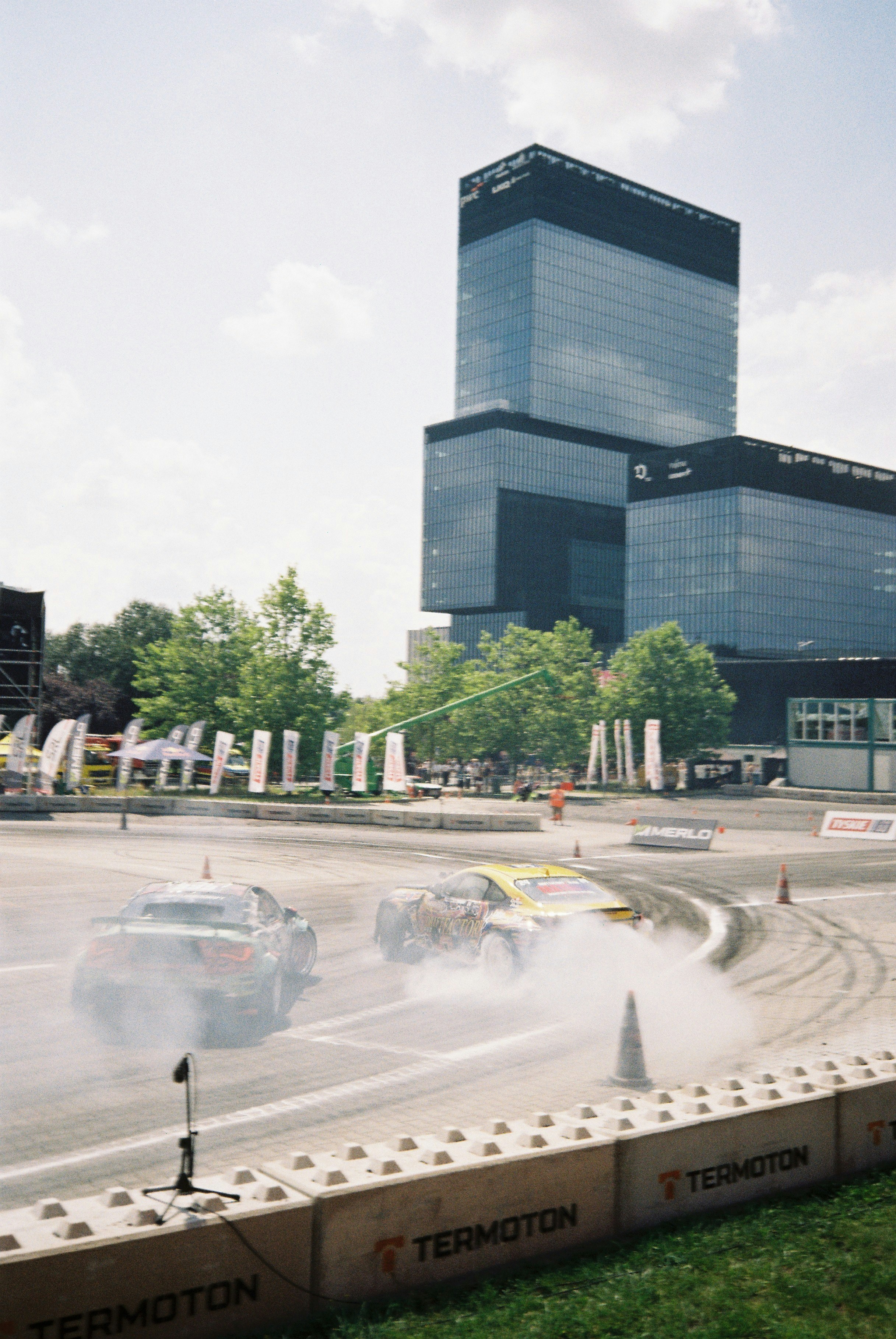 Two cars drifting with smoke in a city setting