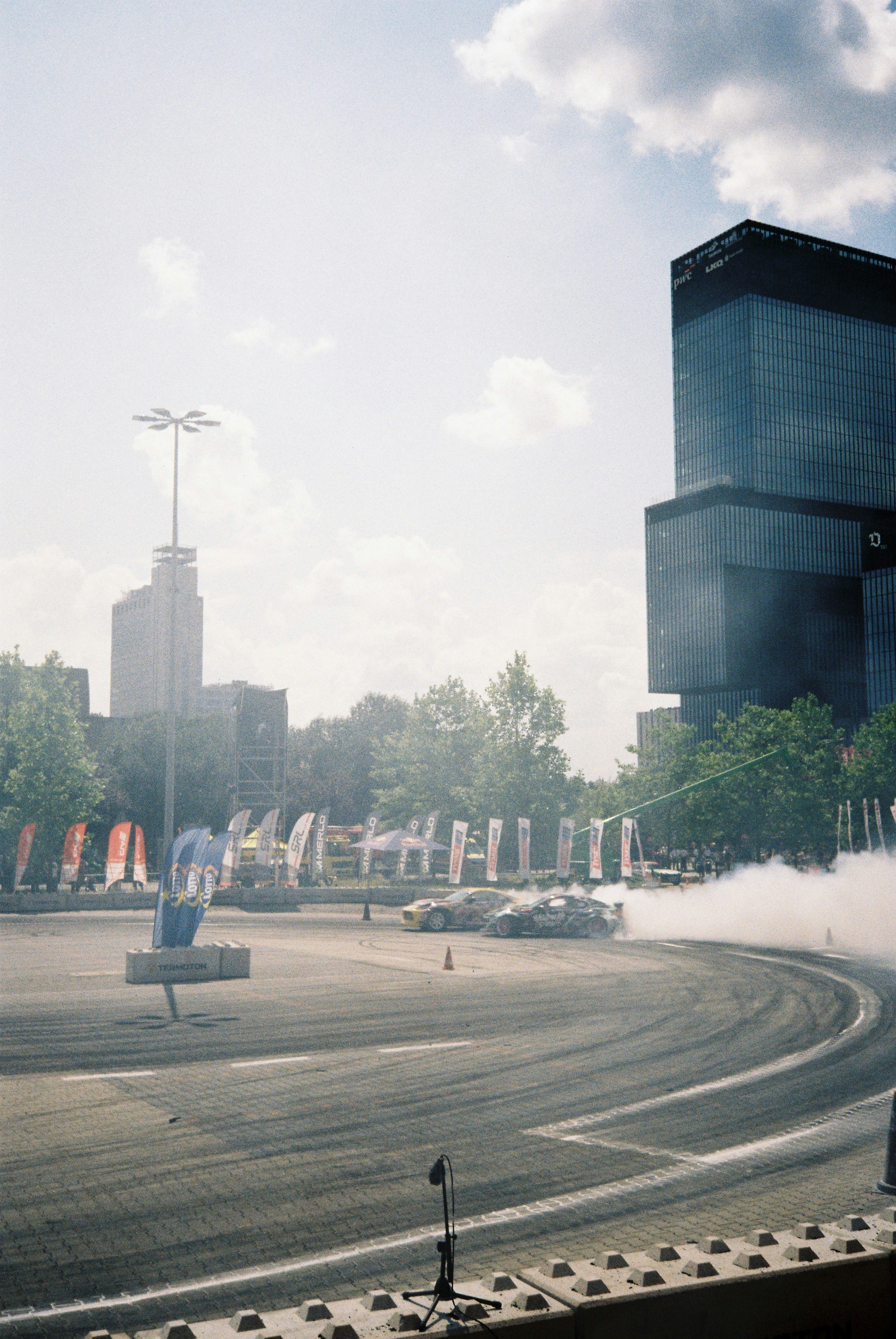 Cars drifting and smoking on a city street with buildings