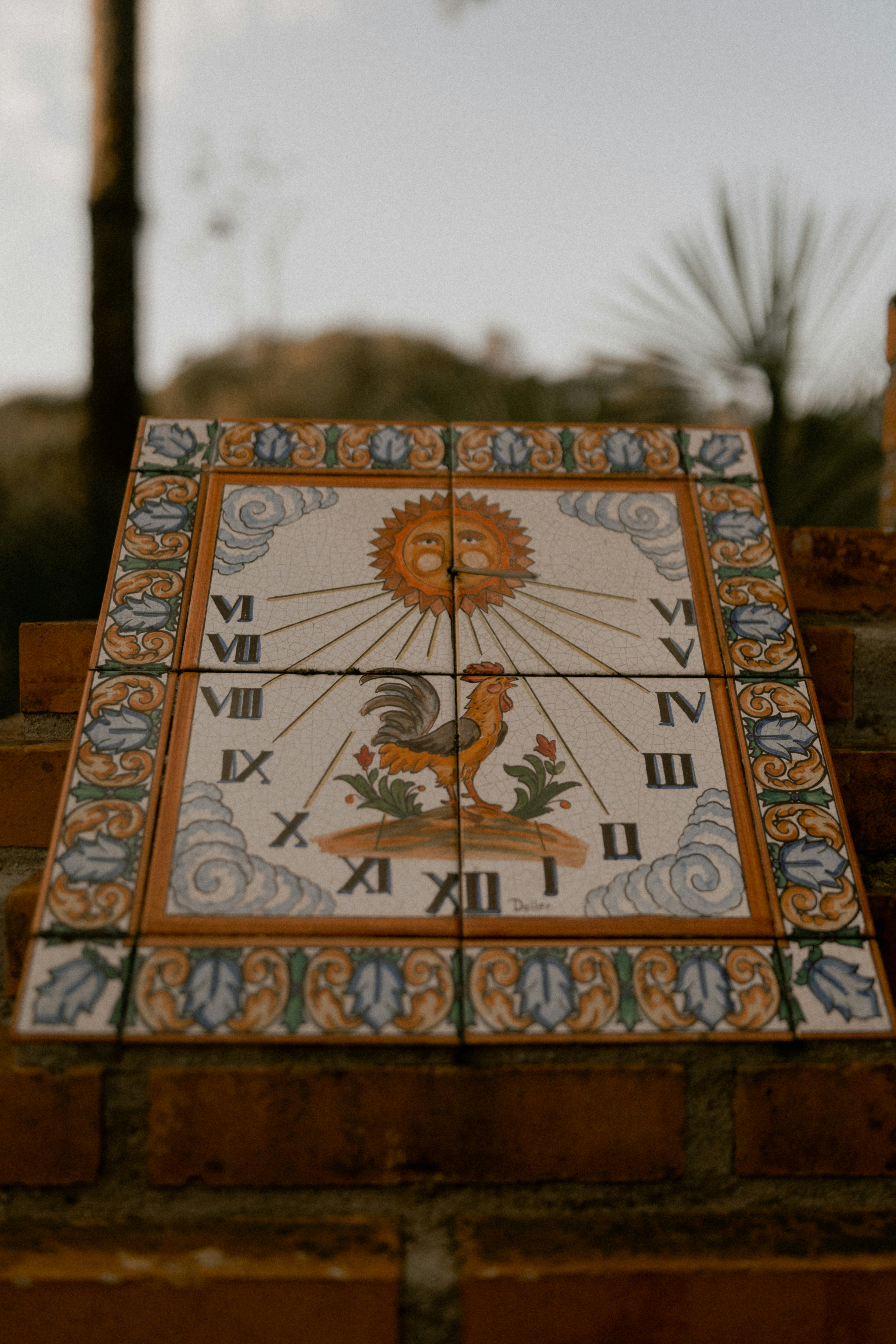 Decorative ceramic sundial featuring a rooster and sun design