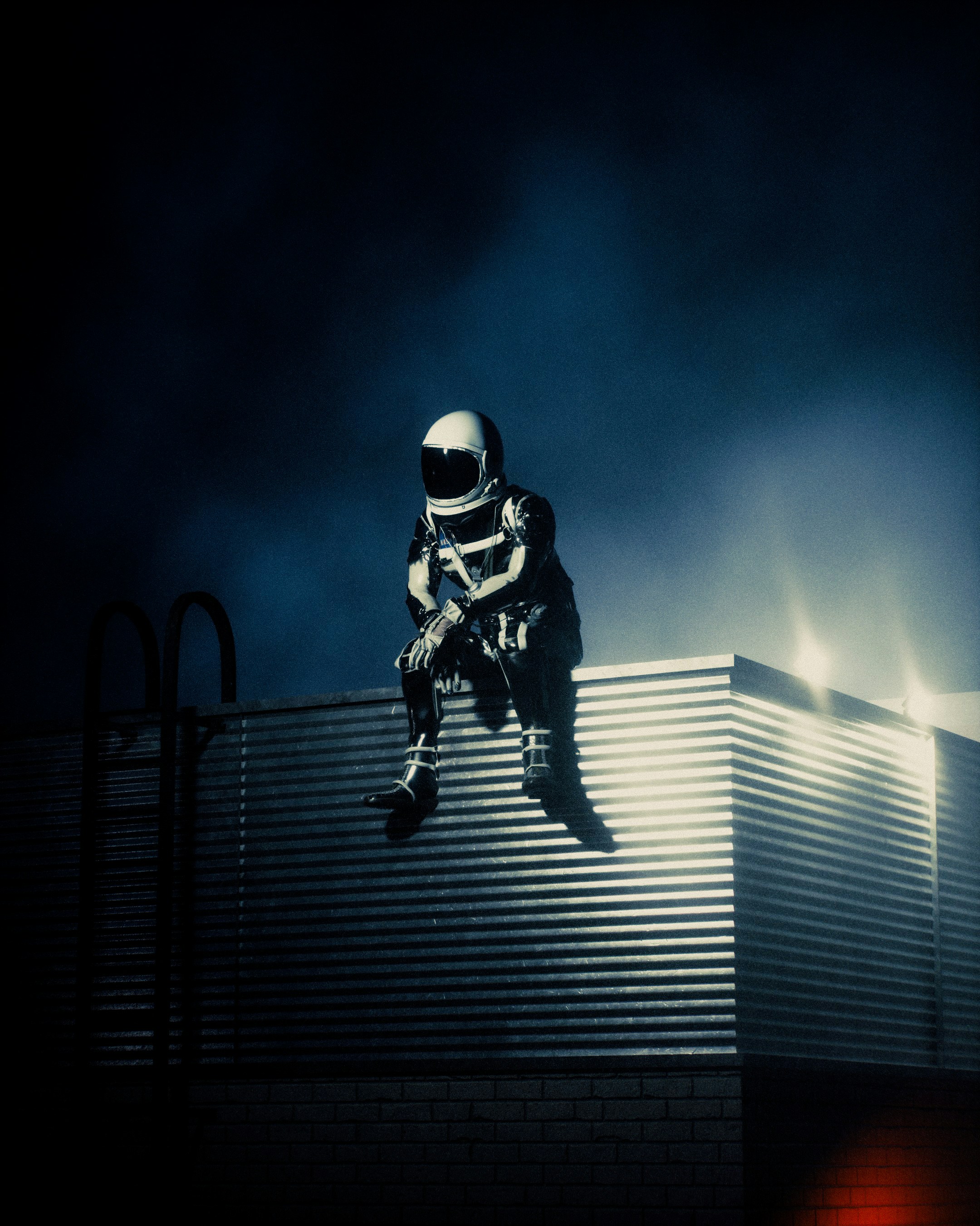 Astronaut scout sitting on a metallic structure in darkness