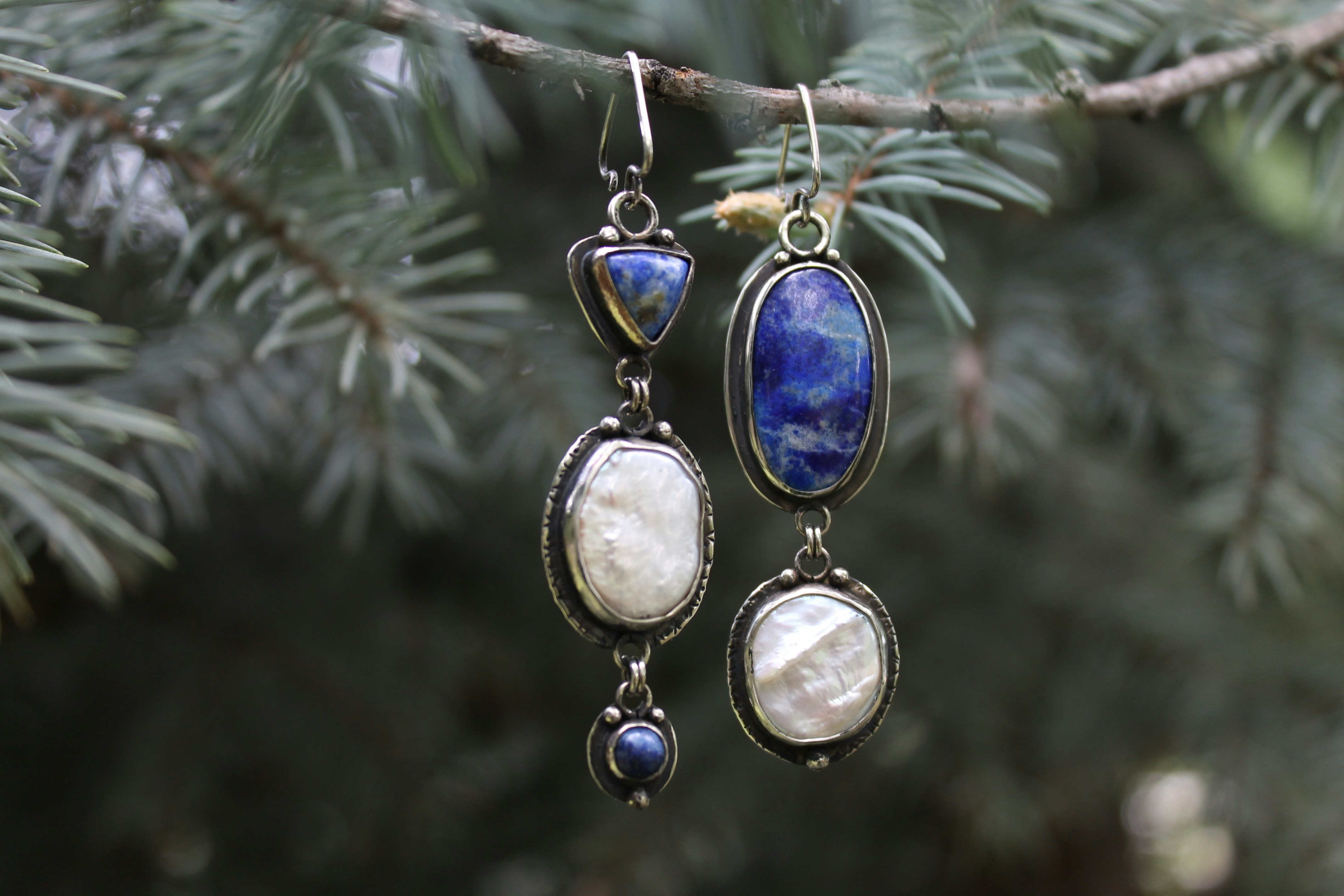Élégantes boucles d’oreilles pendantes avec des pierres bleues et blanches sur du pin